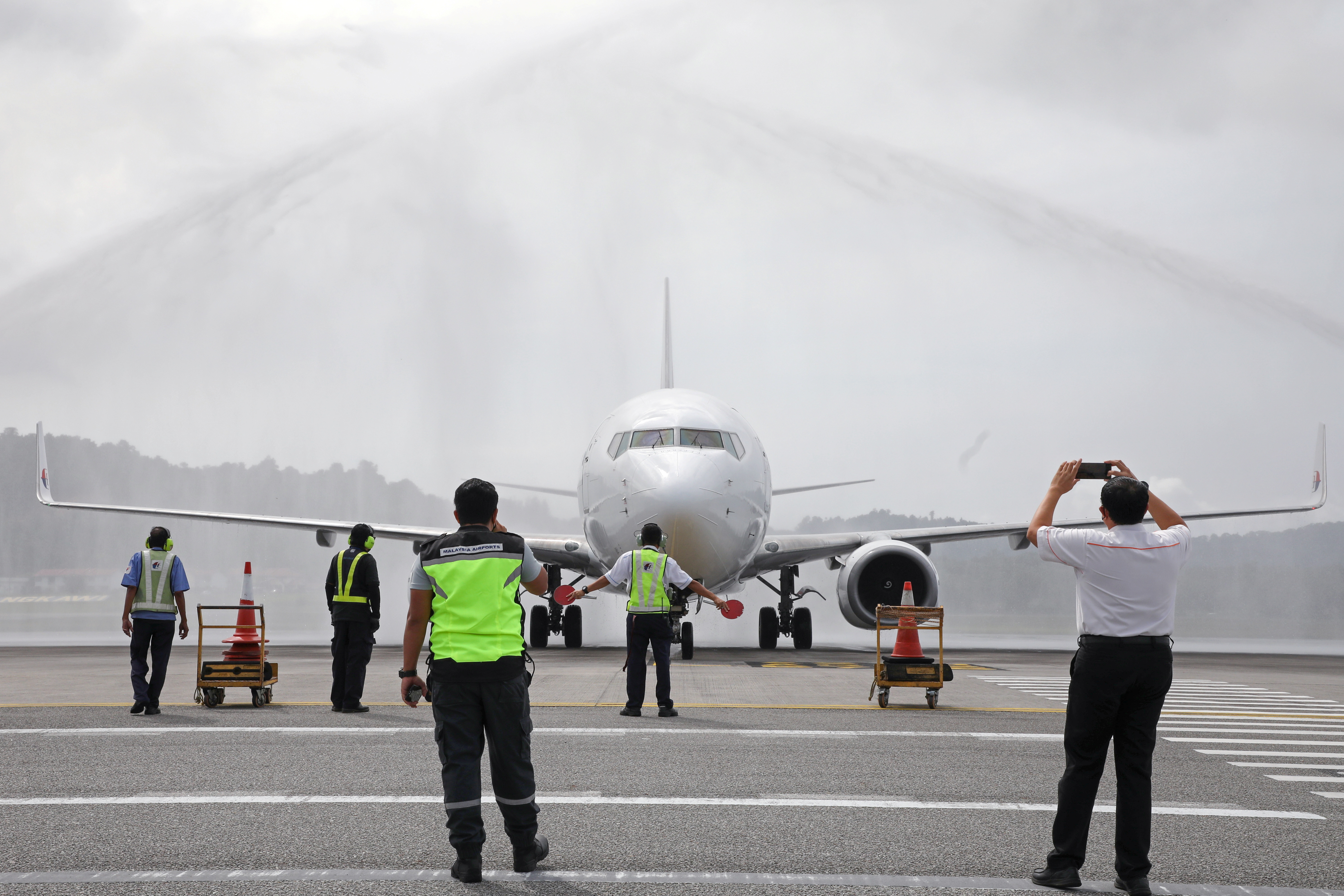 A Malaysia Airlines plane carrying the first batch of tourists receives a water cannon salute from water trucks as Langkawi reopens to domestic tourists, amid the coronavirus disease (COVID-19) pandemic in Malaysia September 16, 2021. REUTERS/Lim Huey Teng