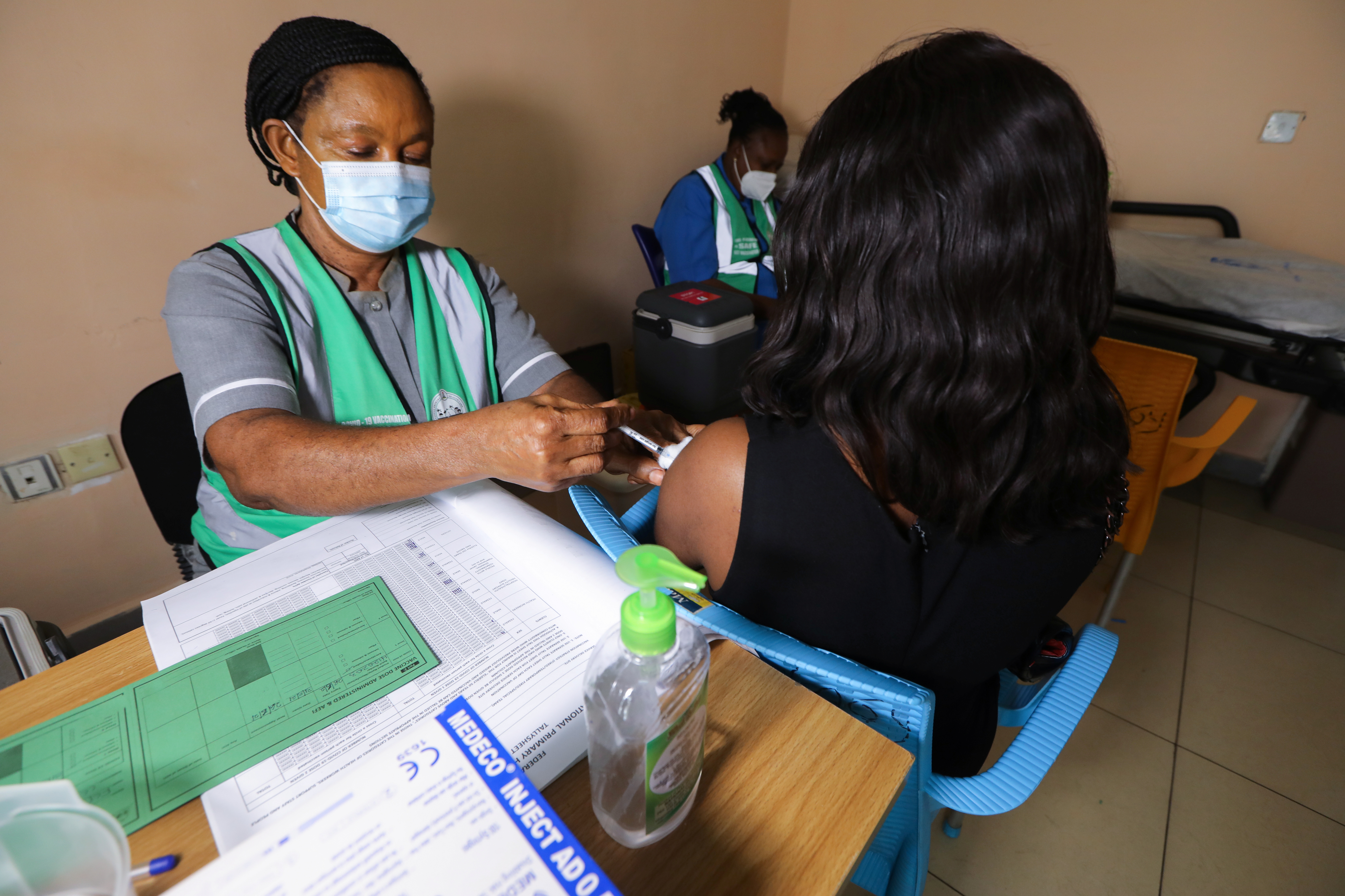 A medical worker injects the AstraZeneca's COVID-19 vaccine to a woman at the Nationa Hospital in Abuja