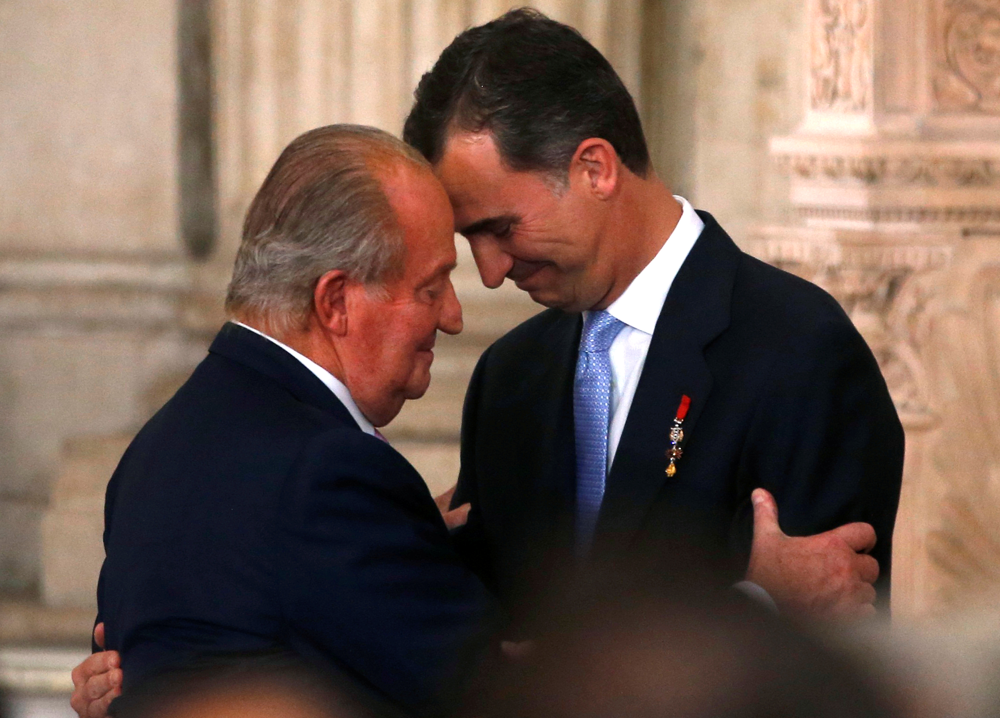 FILE PHOTO: Spain's King Juan Carlos and his son Crown Prince Felipe attend the signature ceremony of the act of abdication at the Royal Palace in Madrid