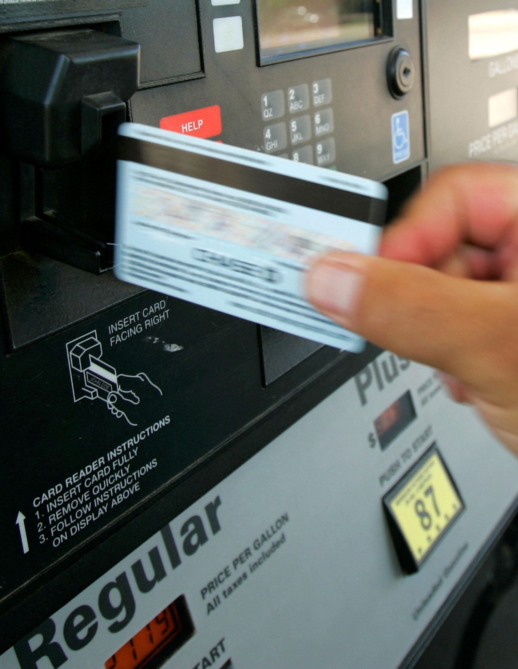 Customer swipes credit card at a gas pump at a Phillips 66 gas station in Centennial, Colorado