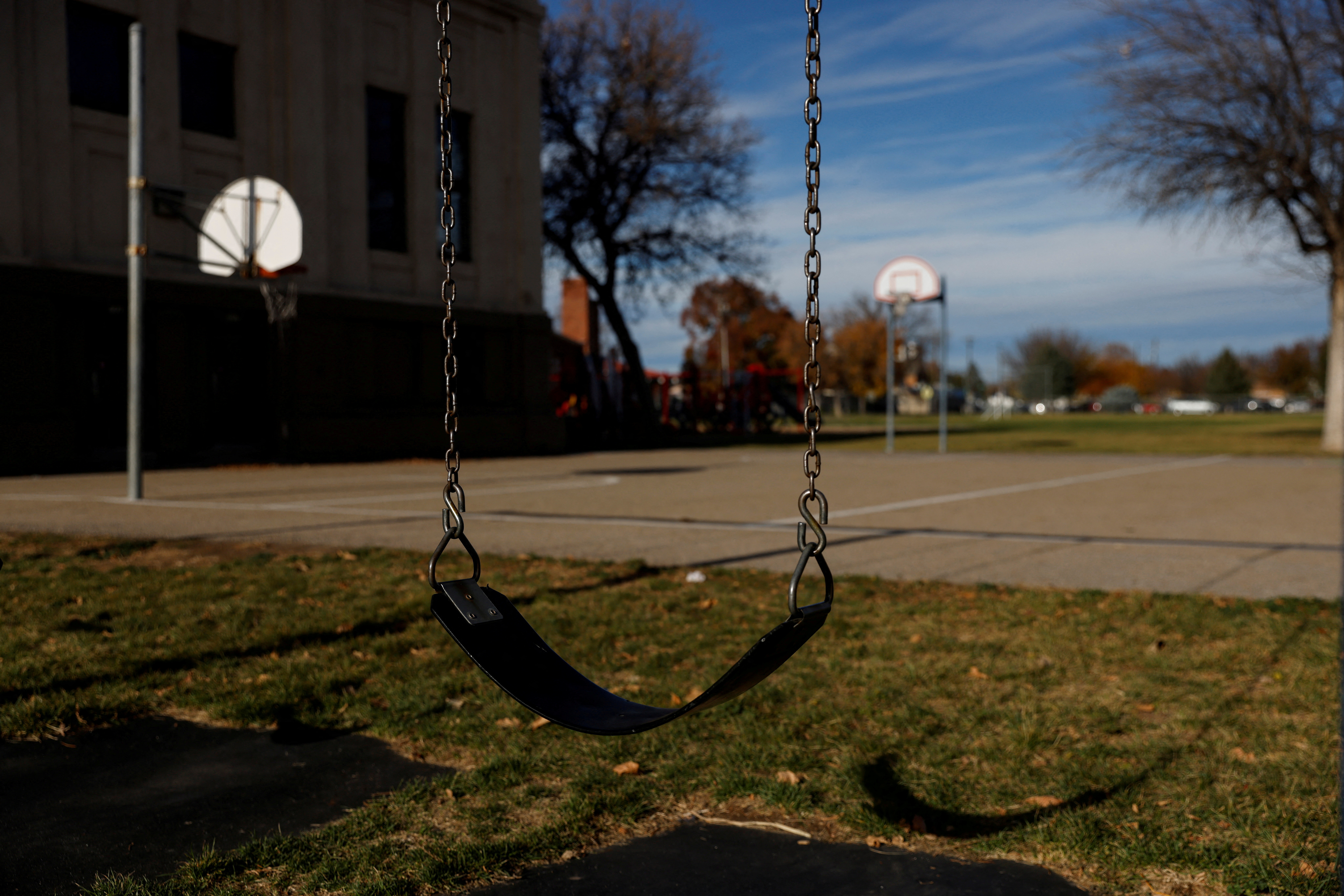 An empty swing hangs on a playground at a middle school in Nampa