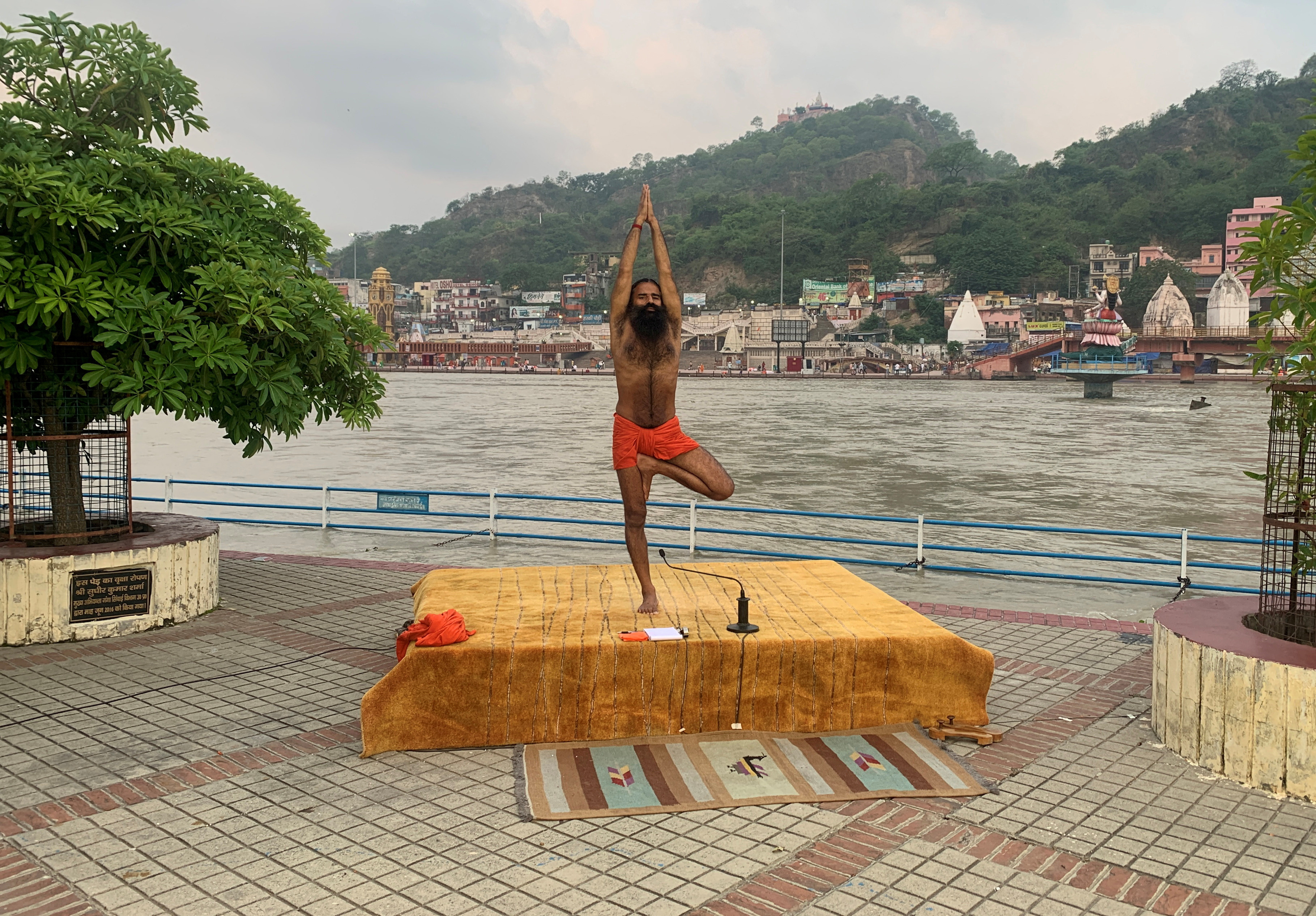 India's yoga guru Baba Ramdev performs yoga on the banks of the river Ganges ahead of International Yoga day, in Haridwar