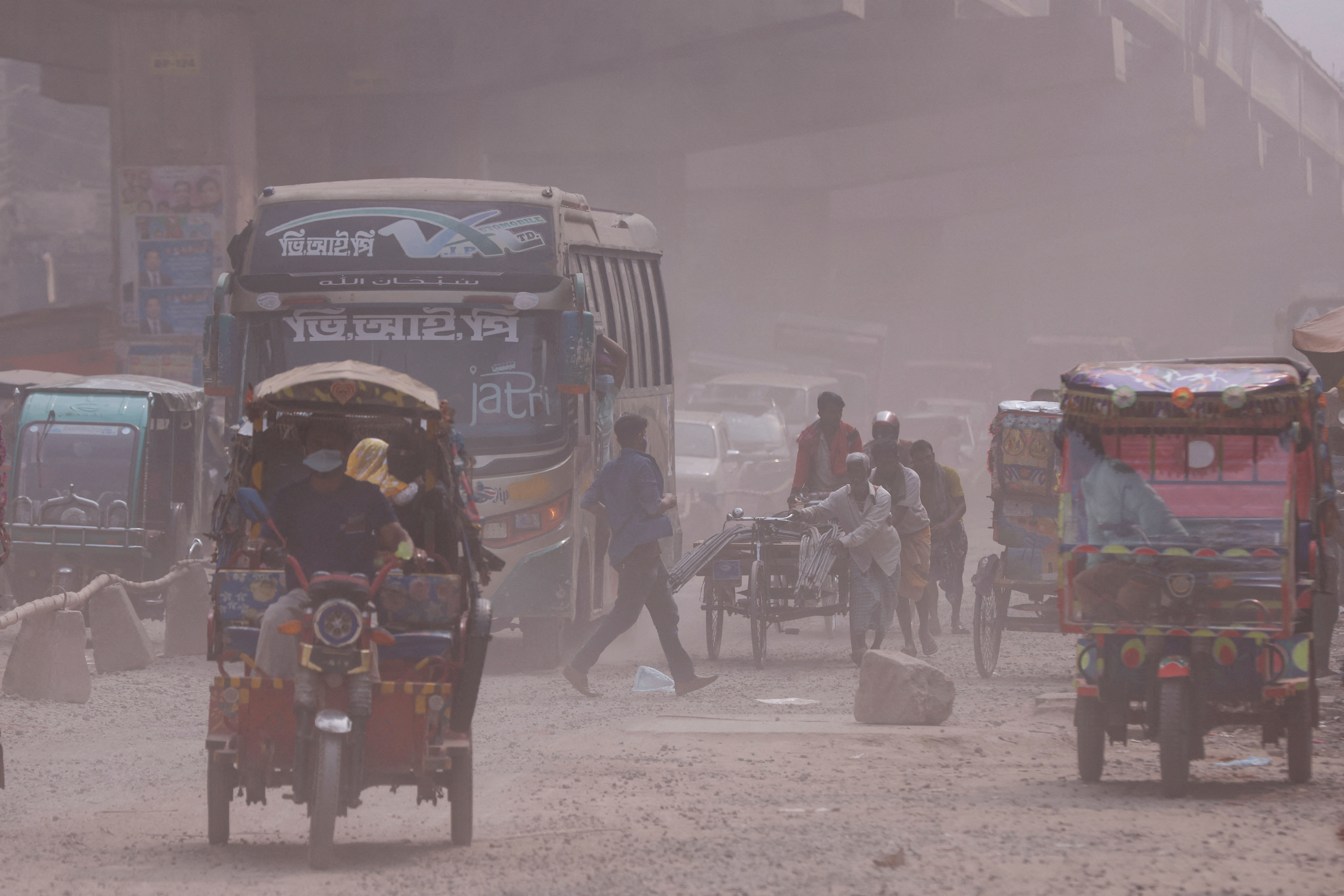 Vehicles are moving on a dusty road as air pollution worsens during winters in Tongi area of Gazipur