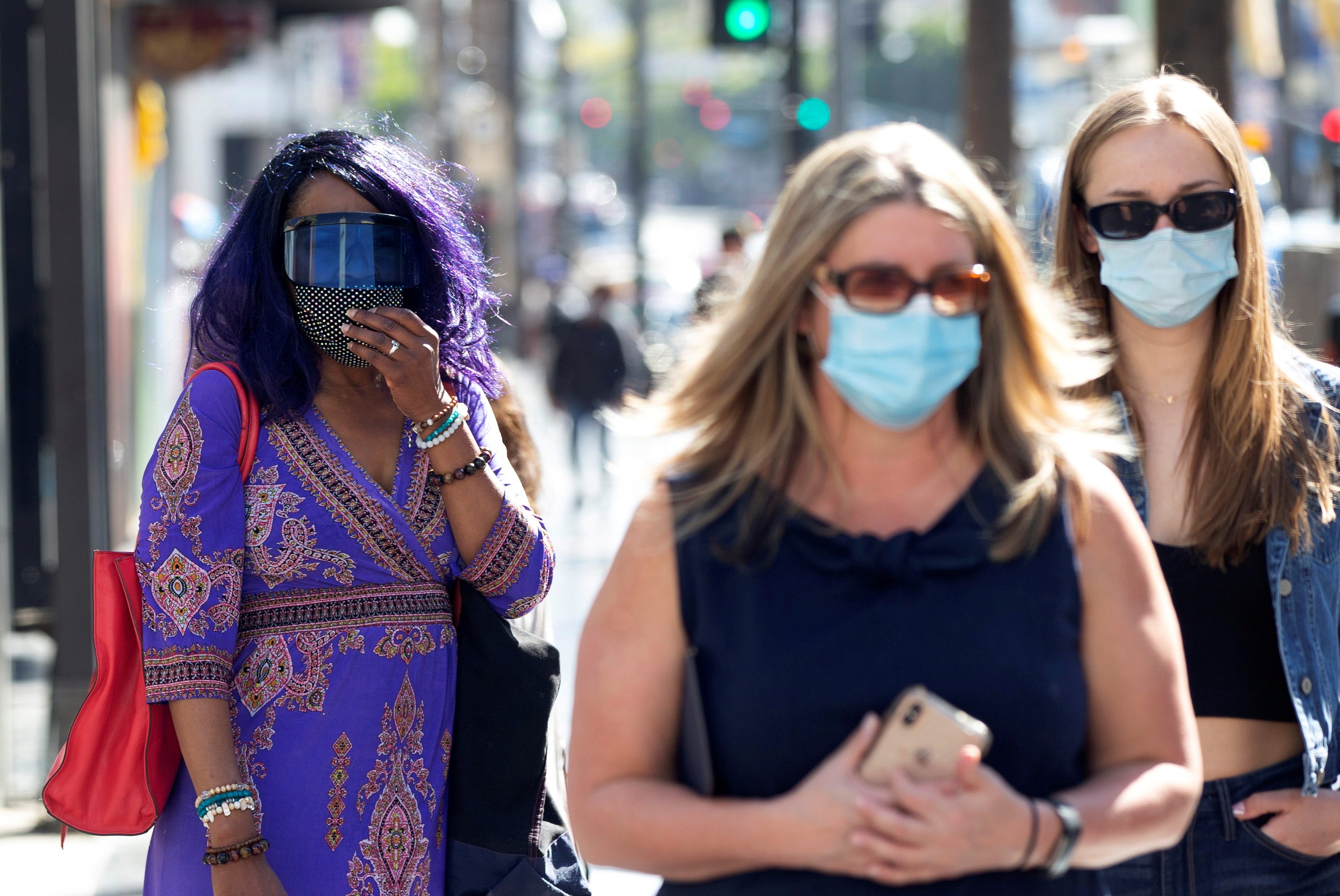 People wearing face protective masks walk on Hollywood Blvd during the outbreak of the coronavirus disease (COVID-19), in Los Angeles