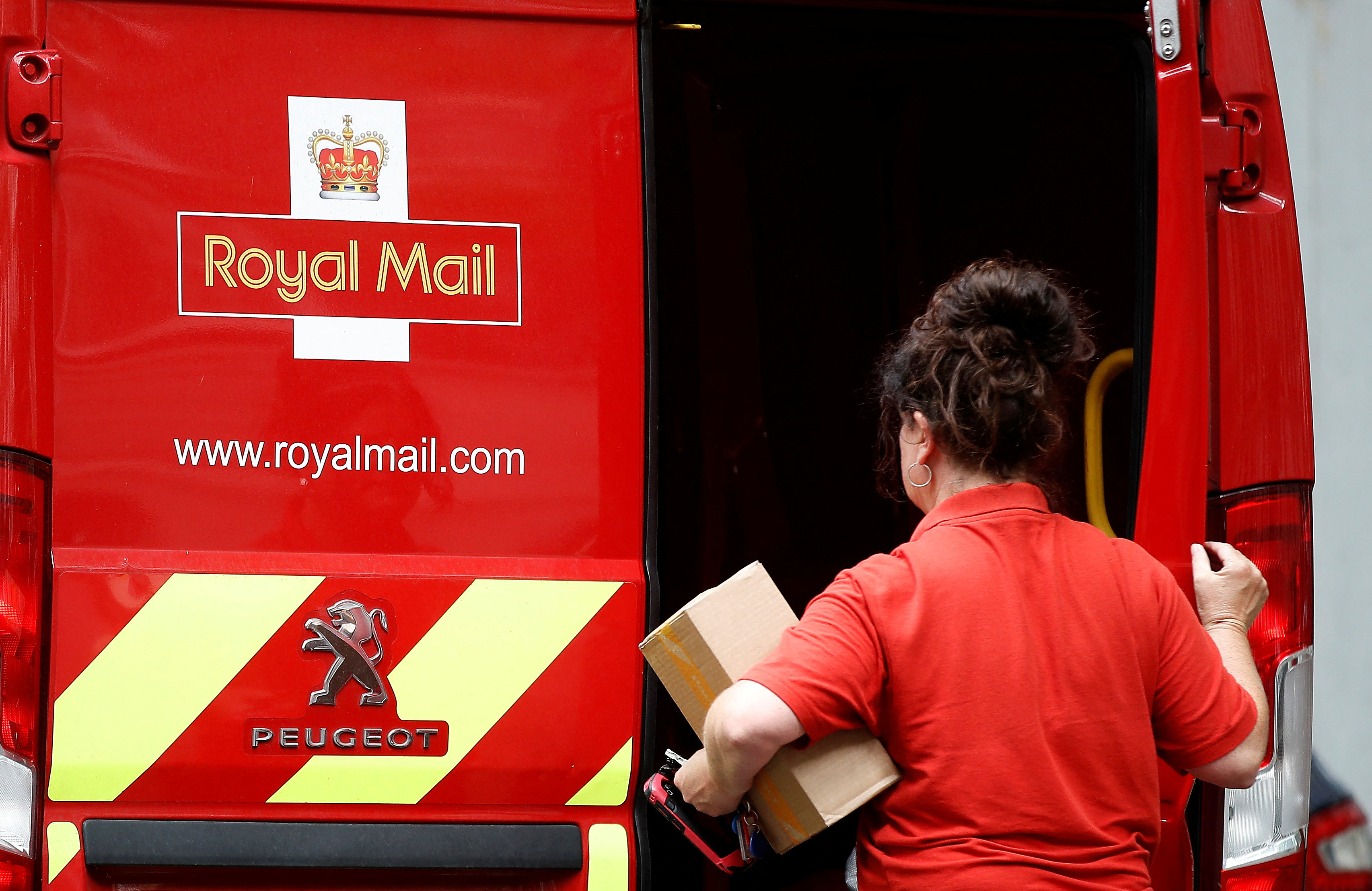 A postal worker makes a delivery in London