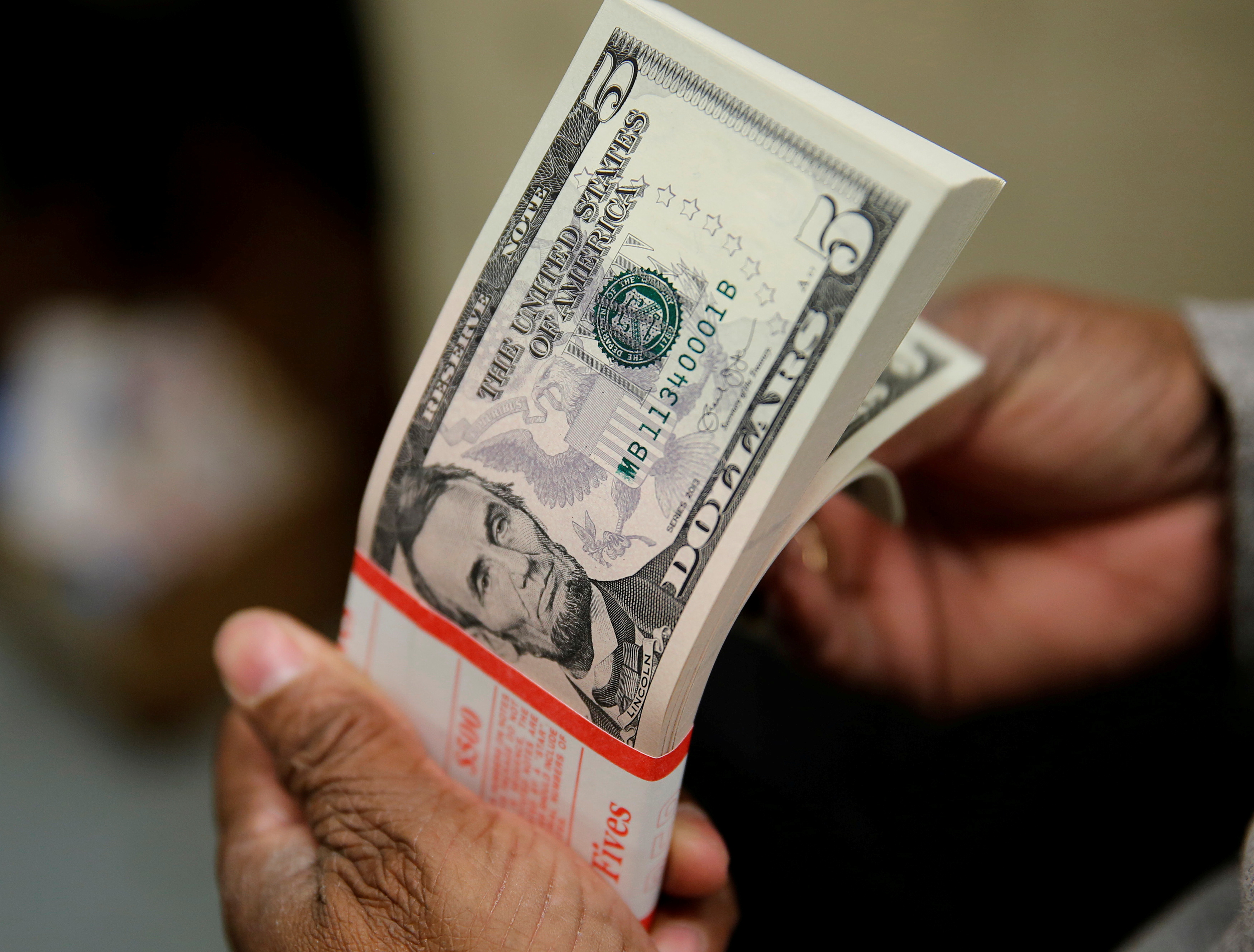 A packet of U.S. five-dollar bills is inspected at the Bureau of Engraving and Printing in Washington March 26, 2015. REUTERS/Gary Cameron//File Photo/File Photo