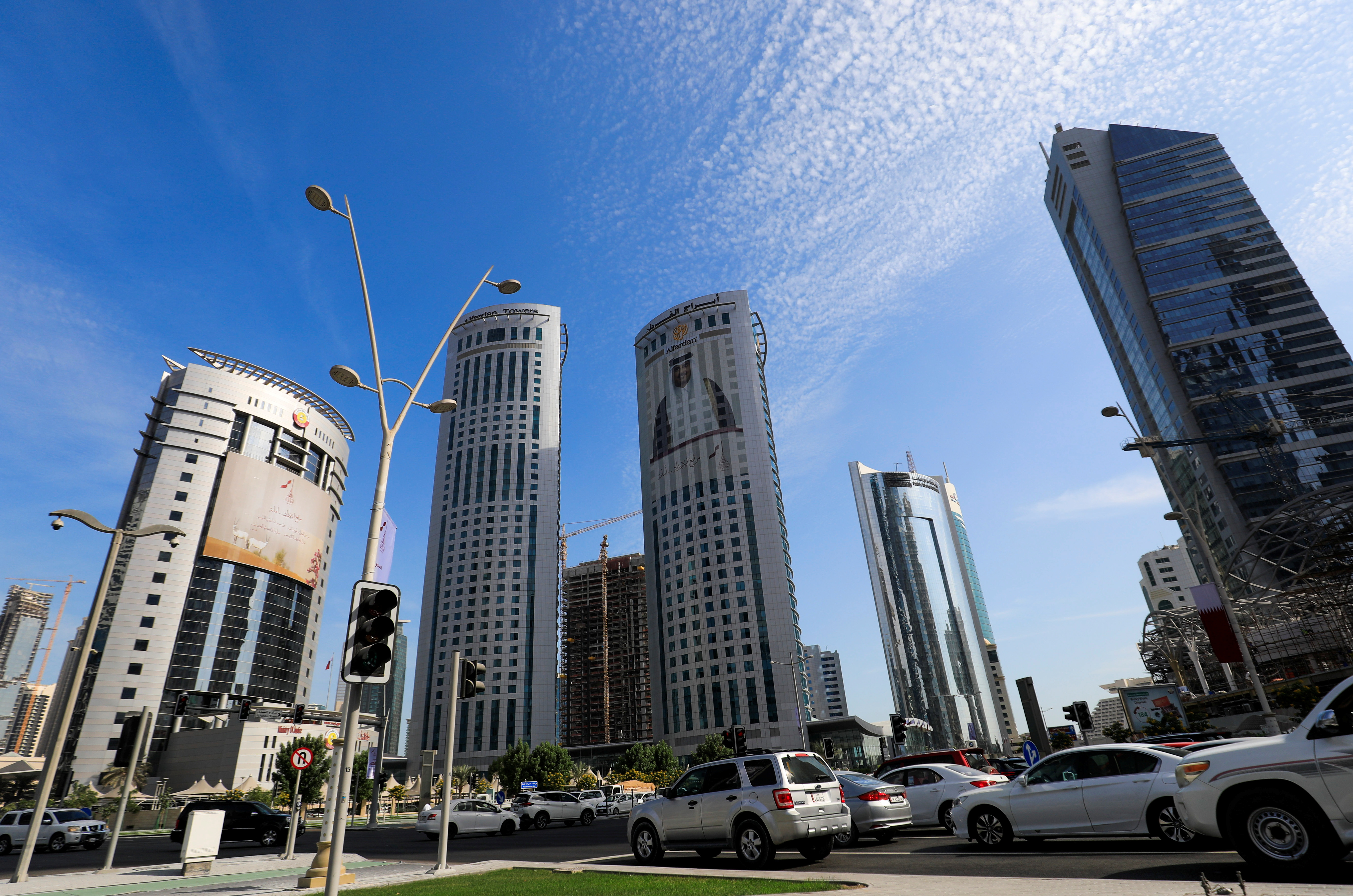 Vehicles are seen in a traffic jam in front of government buildings next to skyscrapers in Doha