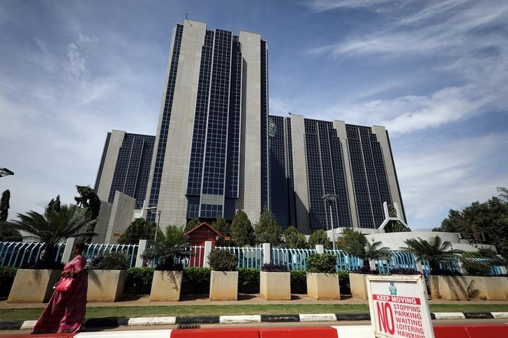 A woman walks past the Central Bank building after the monthly Monetary Policy Committee meeting in Abuja