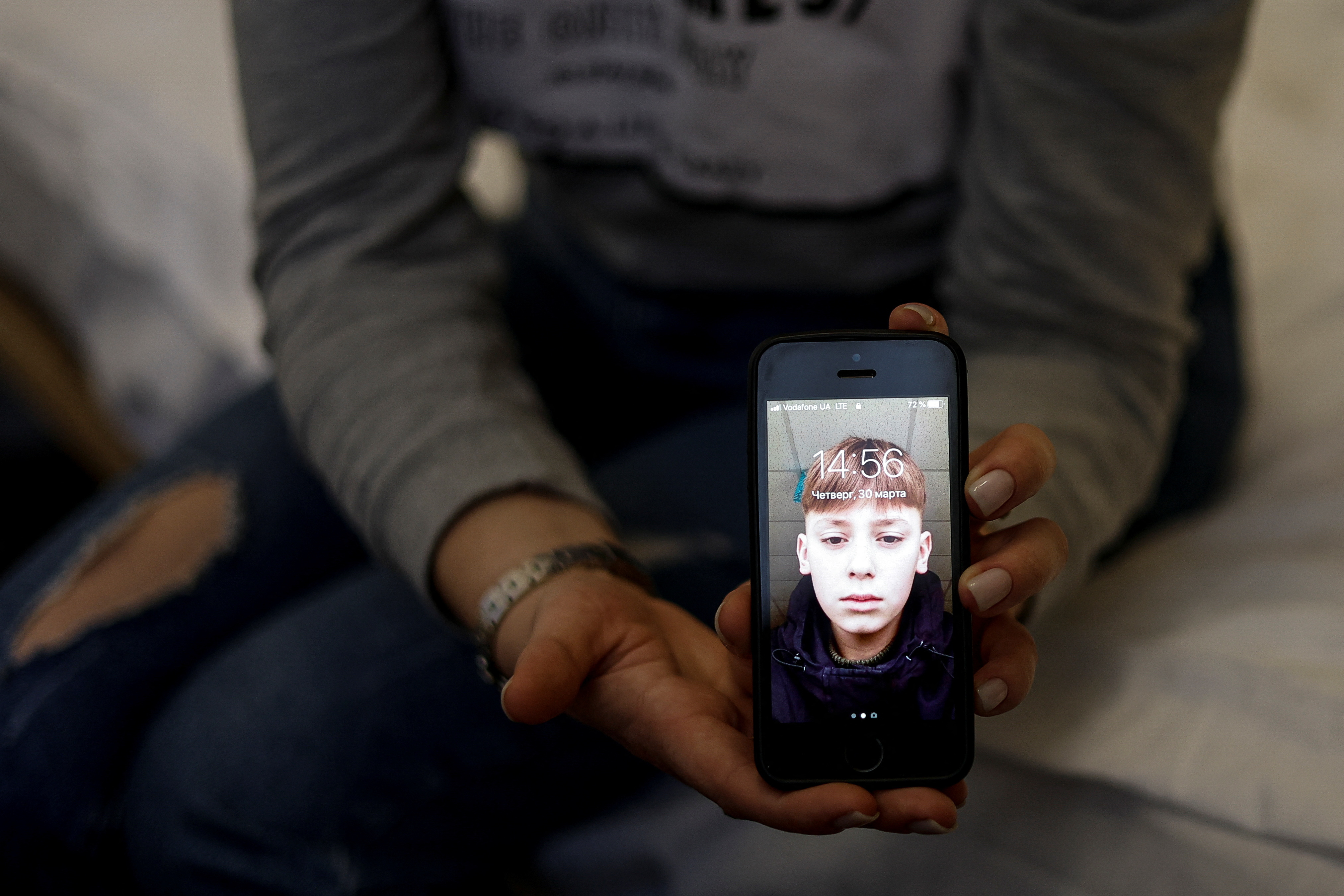 Alla Yatsentiuk shows a picture of her 14-year-old son Danylo as she speaks with Reuters before travelling to Russia to take him back, at a volunteer centre in Kyiv