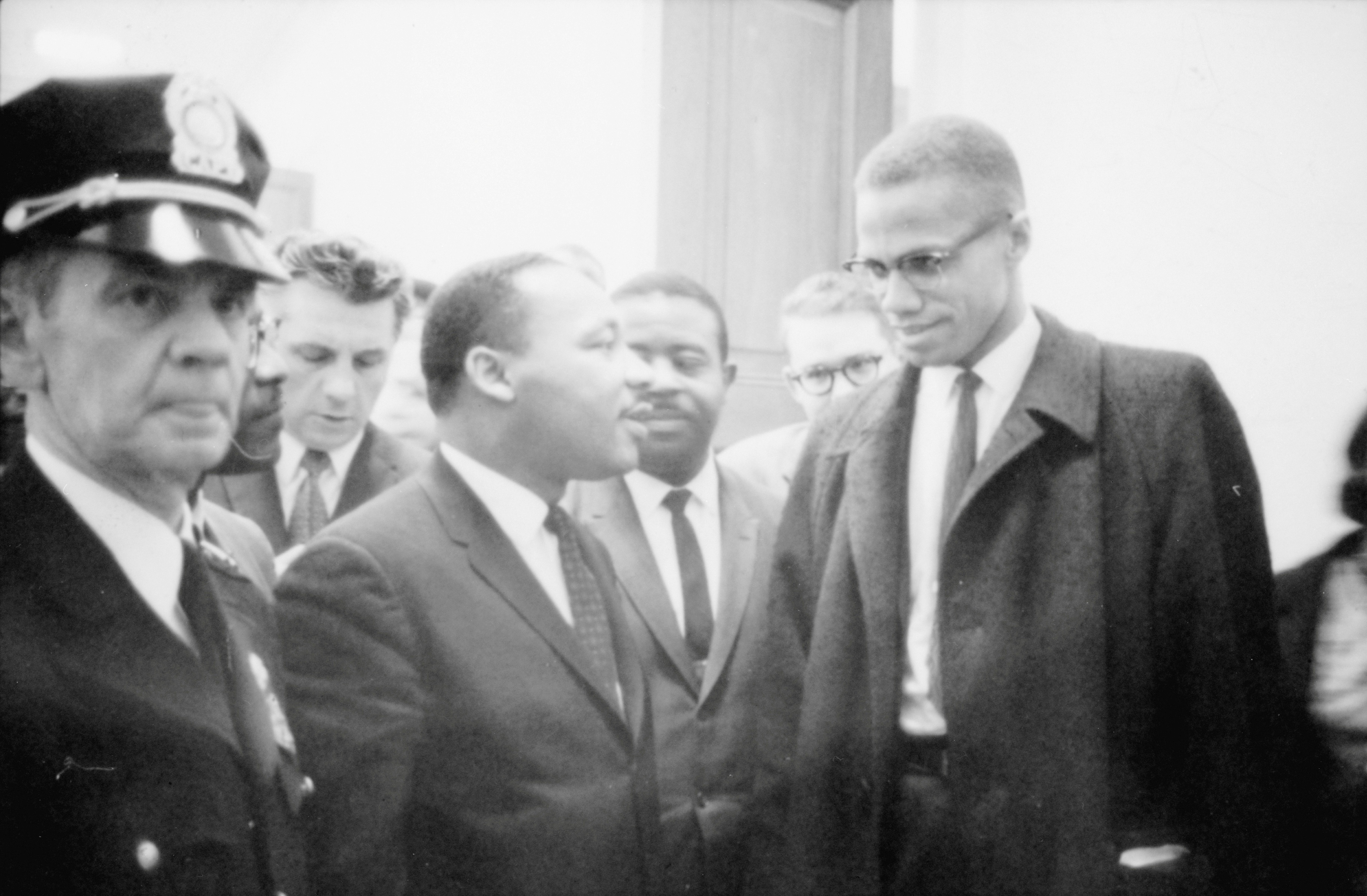 Martin Luther King Jr. and Malcolm X wait for a press conference to begin in an unknown location