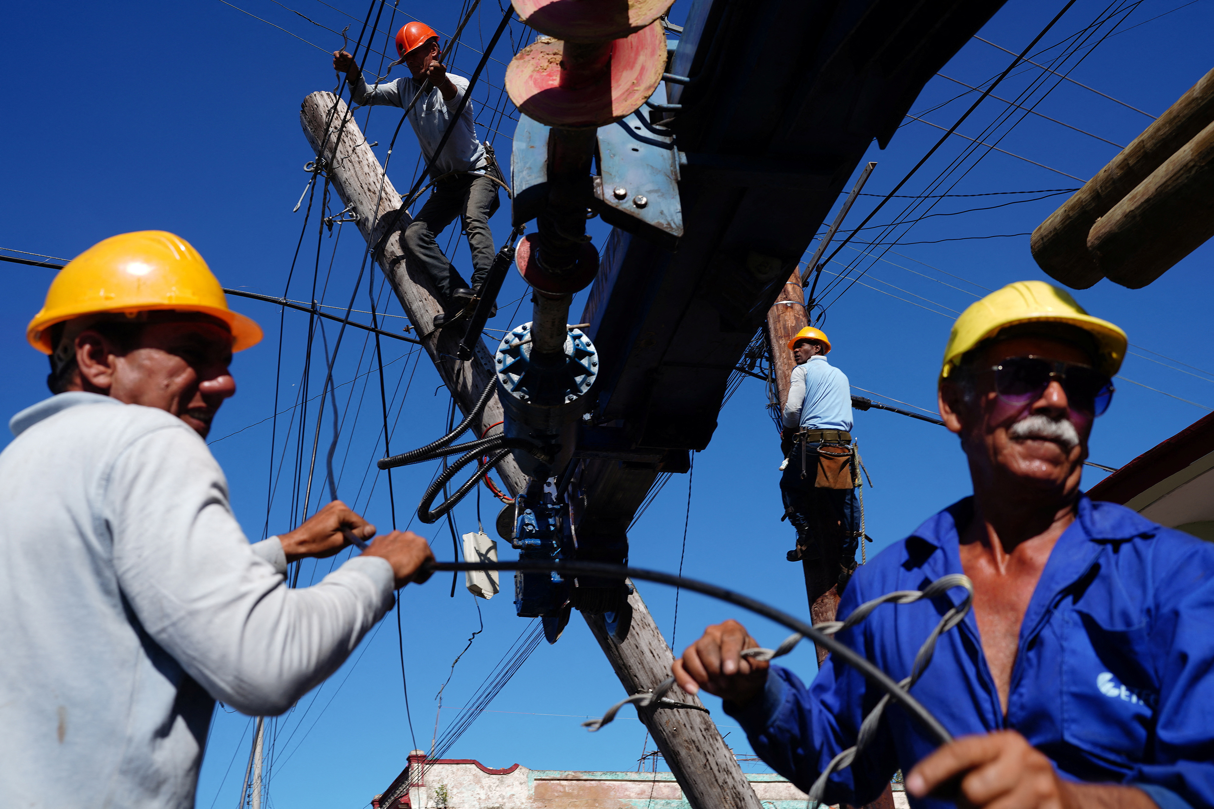 Elektriker reparieren einen Strommast in Pinar del Río, der vonHurrikans Ian beschädigt wurde, 4. Oktober 2022. | Bildquelle: REUTERS © REUTERS/Alexandre Meneghini | Bilder sind in der Regel urheberrechtlich geschützt