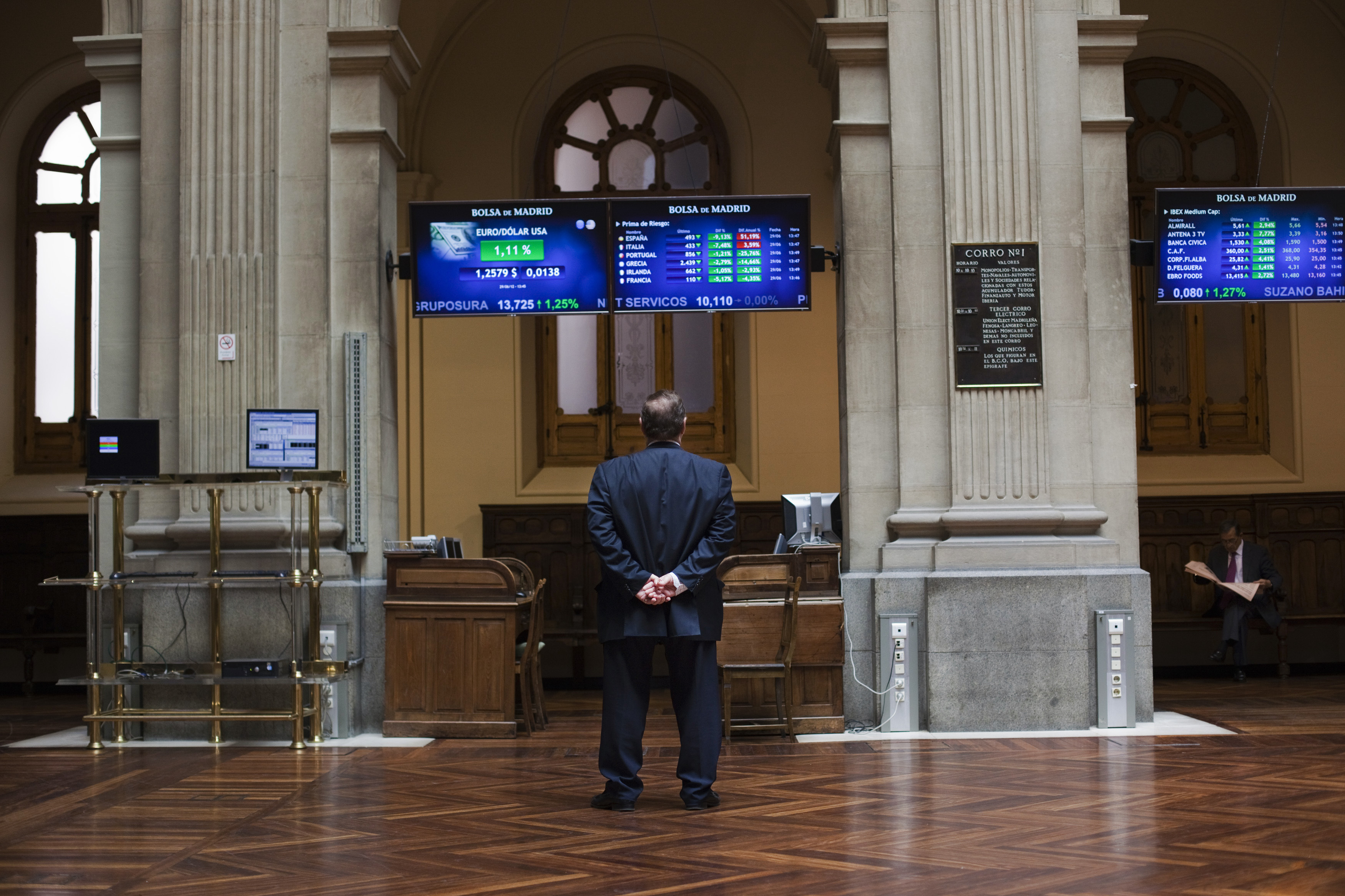 A trader looks at electronic boards at Madrid's stock exchange