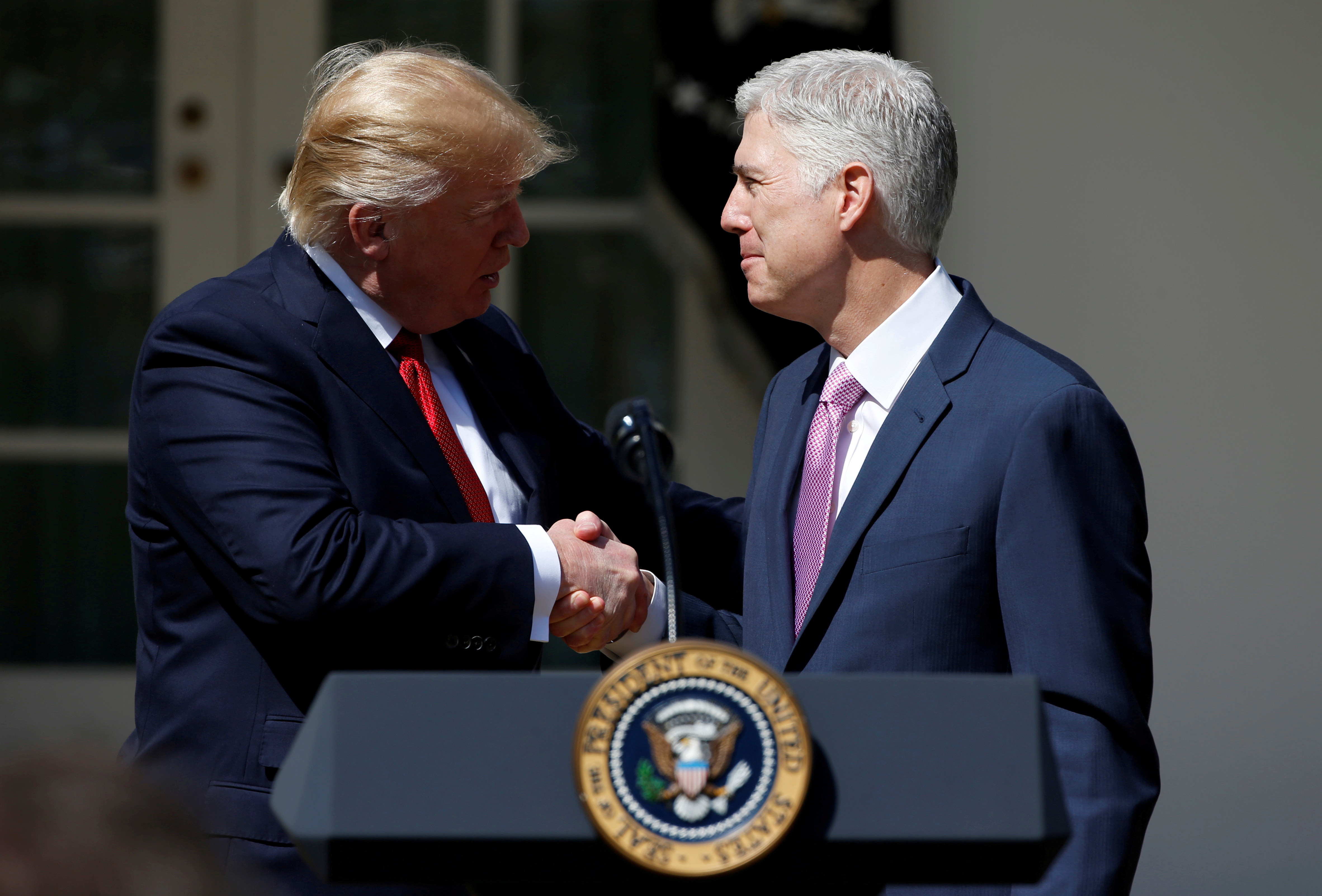 U.S. President Donald Trump shakes hands with Judge Neil Gorsuch after he was sworn in as an Associate Supreme Court in the Rose Garden of the White House in Washington, U.S., April 10, 2017. REUTERS/Joshua Roberts/File Photo