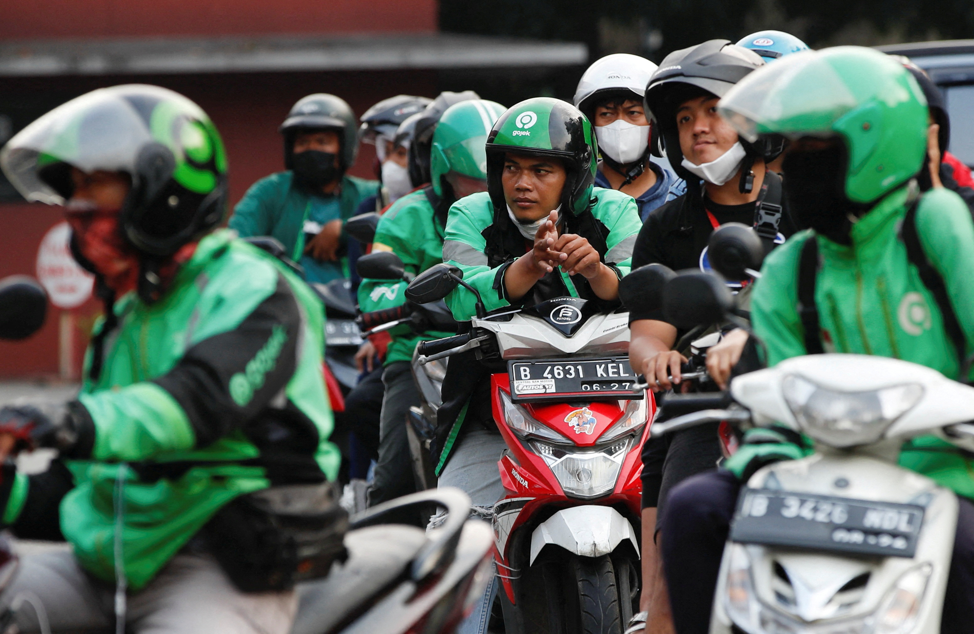 Motorcycle drivers wait in line to buy subsidised fuel at a petrol station of the state-owned company Pertamina, in Jakarta