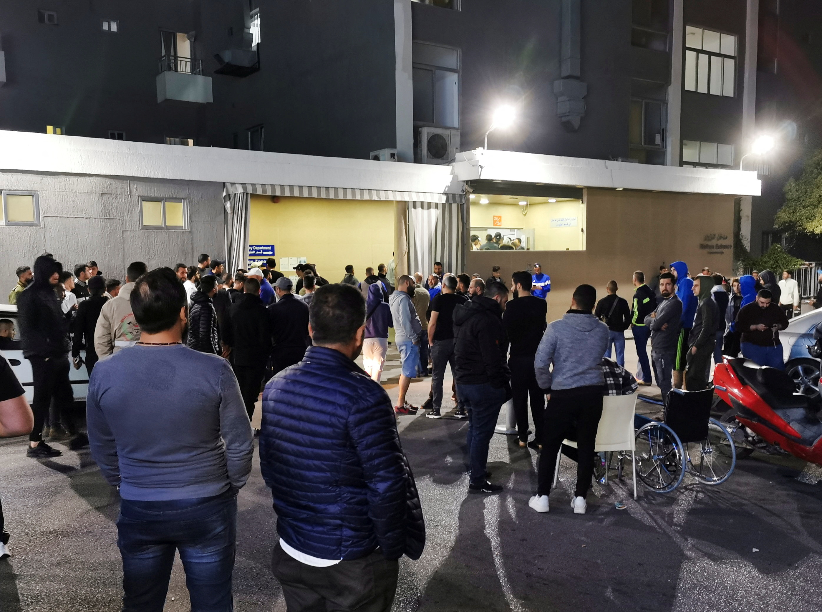 Men gather outside a hospital after an explosion, near Sidon
