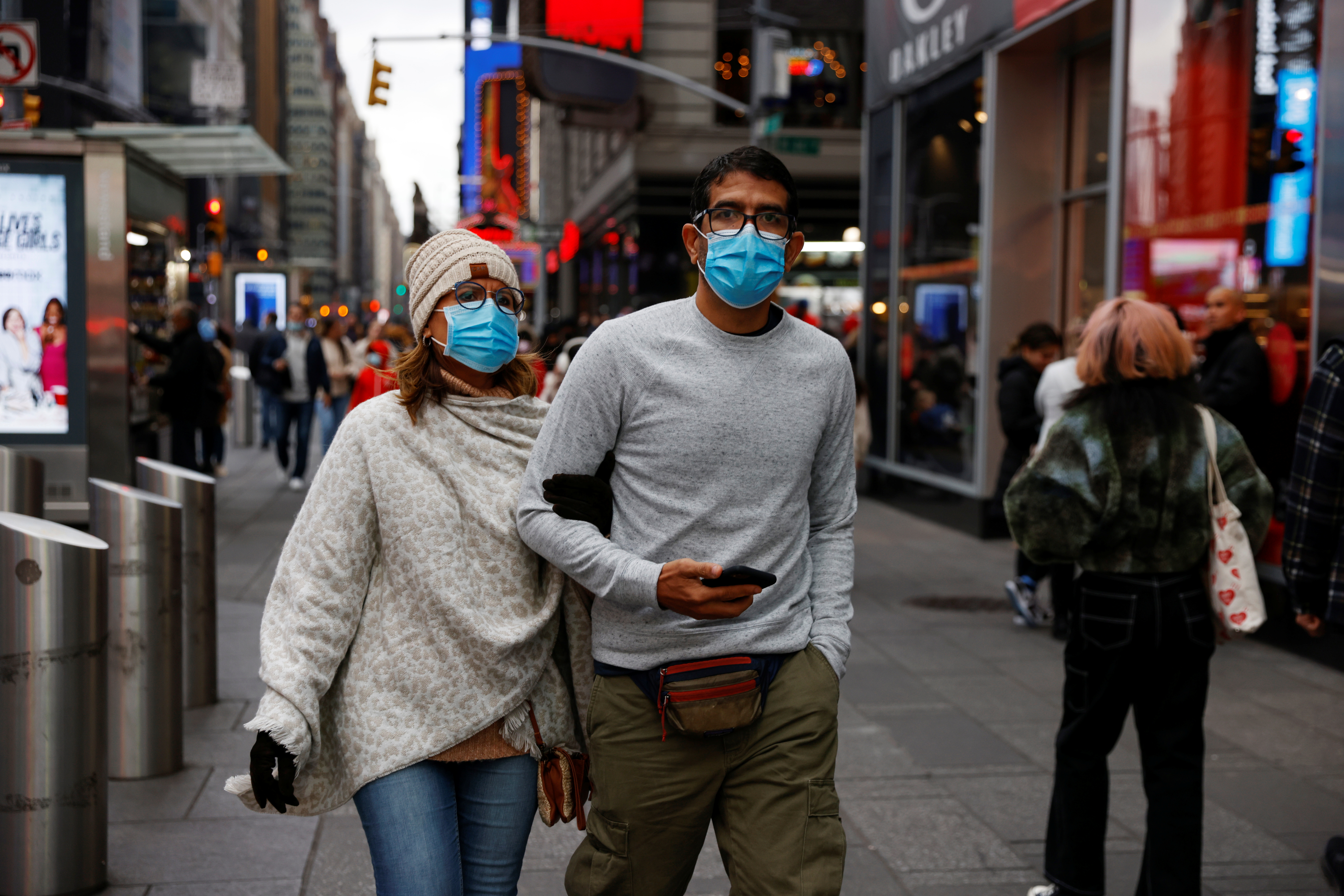 People wearing protective face masks, amid the coronavirus disease (COVID-19) pandemic, walk through Times Square in New York City