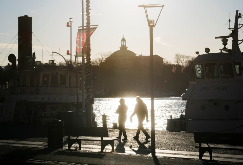 People stroll in the cold but sunny weather along Standvagen quayside, amid the continuous spread of the coronavirus disease (COVID-19) pandemic in Stockholm