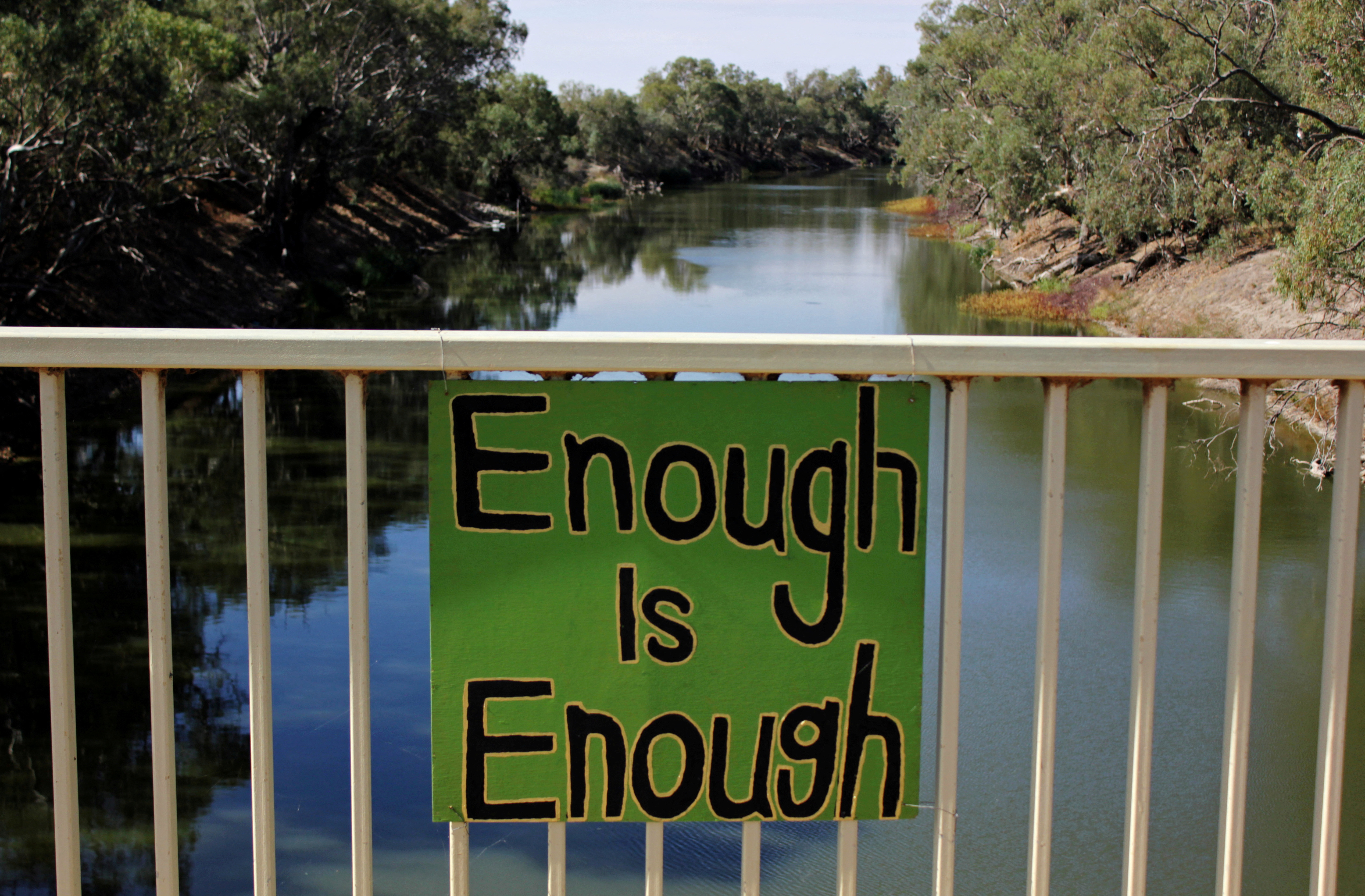 A sign protesting against government management of water allocation is seen on a bridge over the drying-up Darling River at Menindee