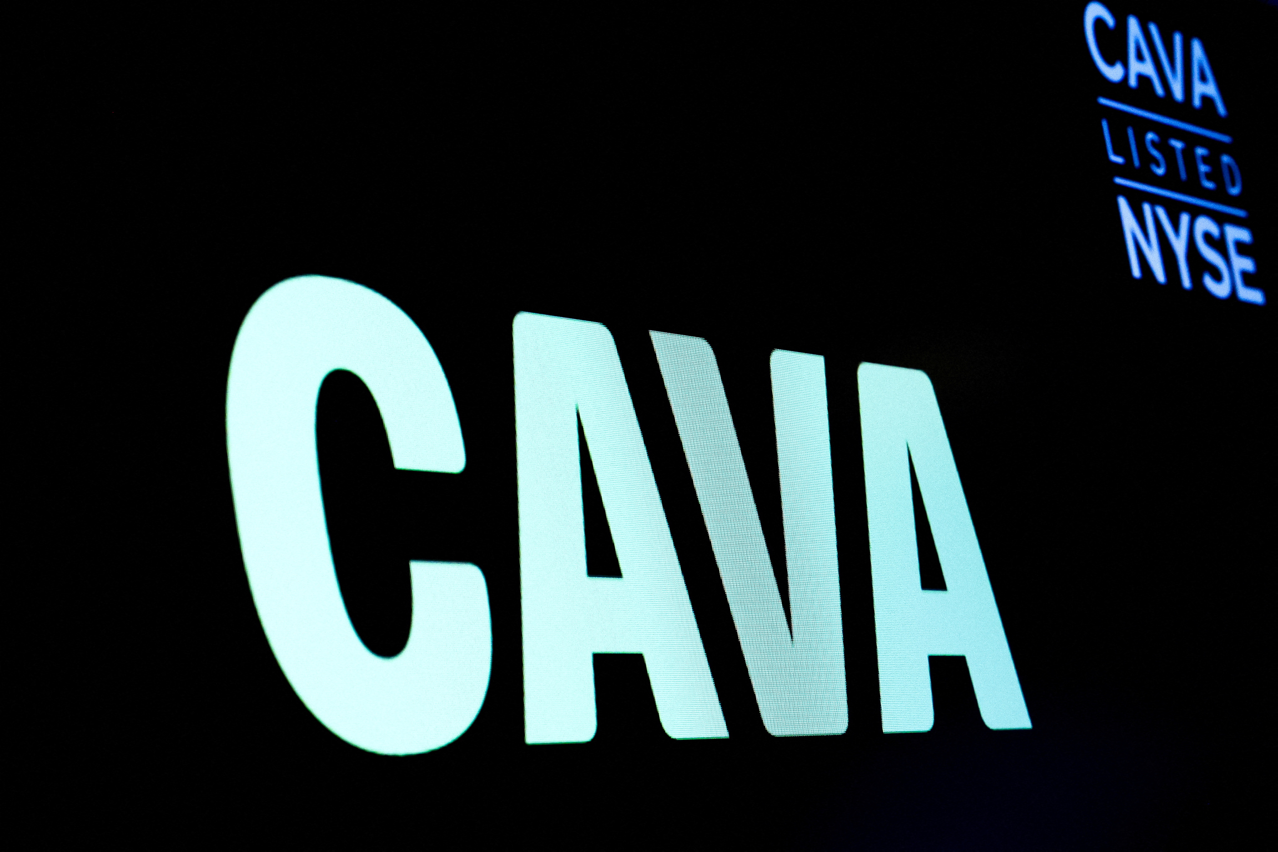 The logo for Cava Group is displayed on a screen on the floor of the NYSE in New York