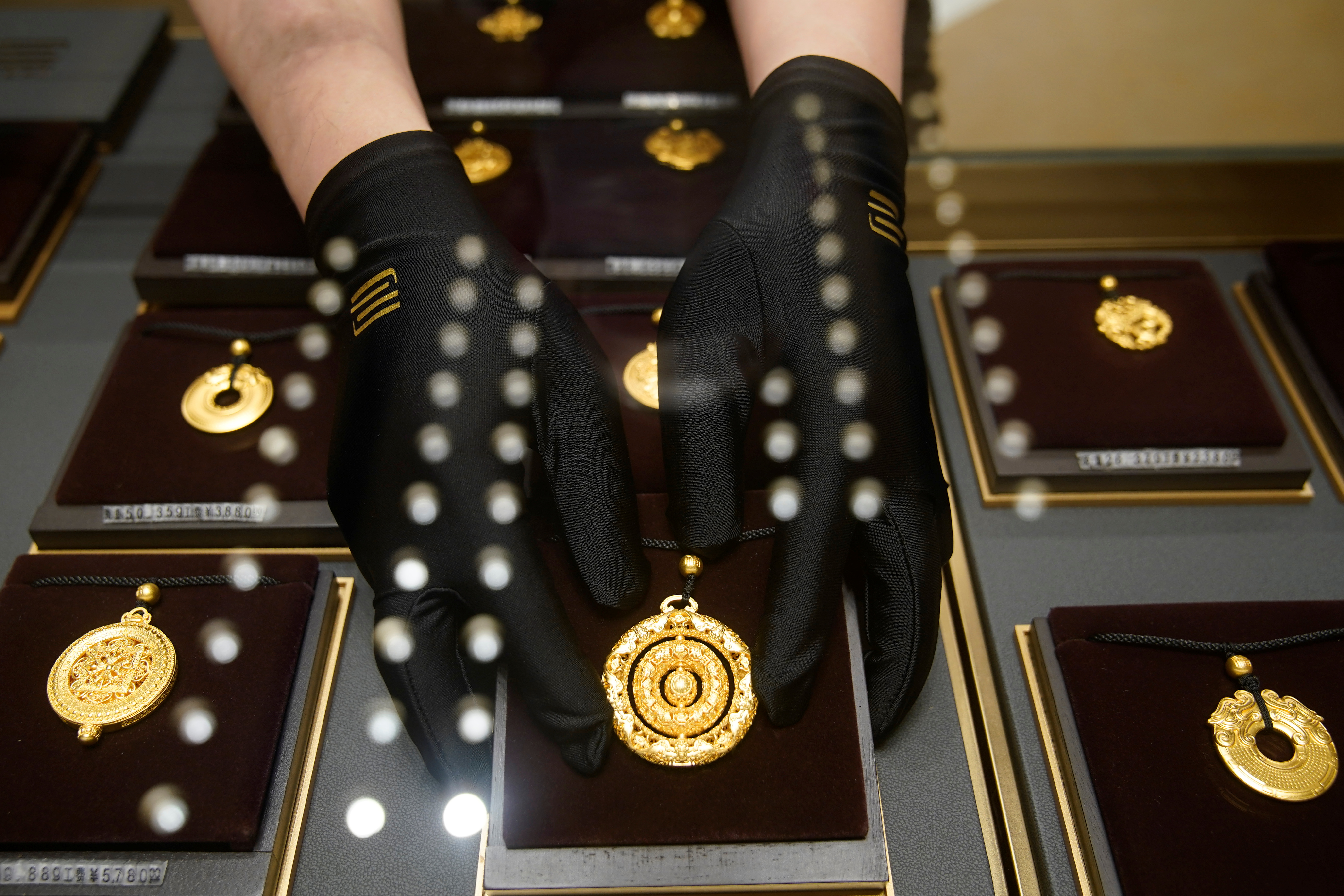 A salesperson poses with Heritage Gold jewellery at jeweller Chow Tai Fook’s retail store in Shanghai