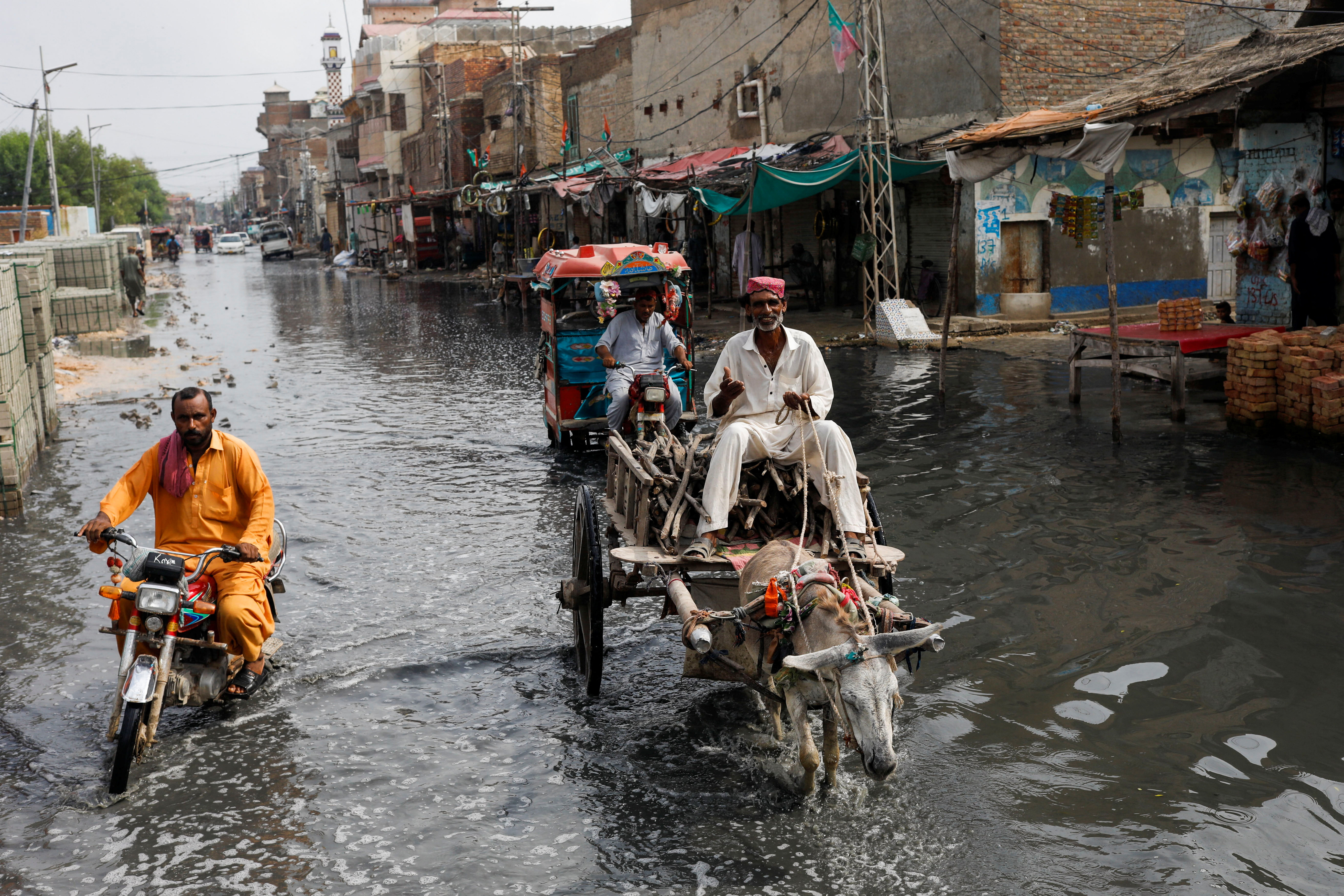 A man rides on donkey cart through rain waters, following rains and floods during the monsoon season in Jacobabad