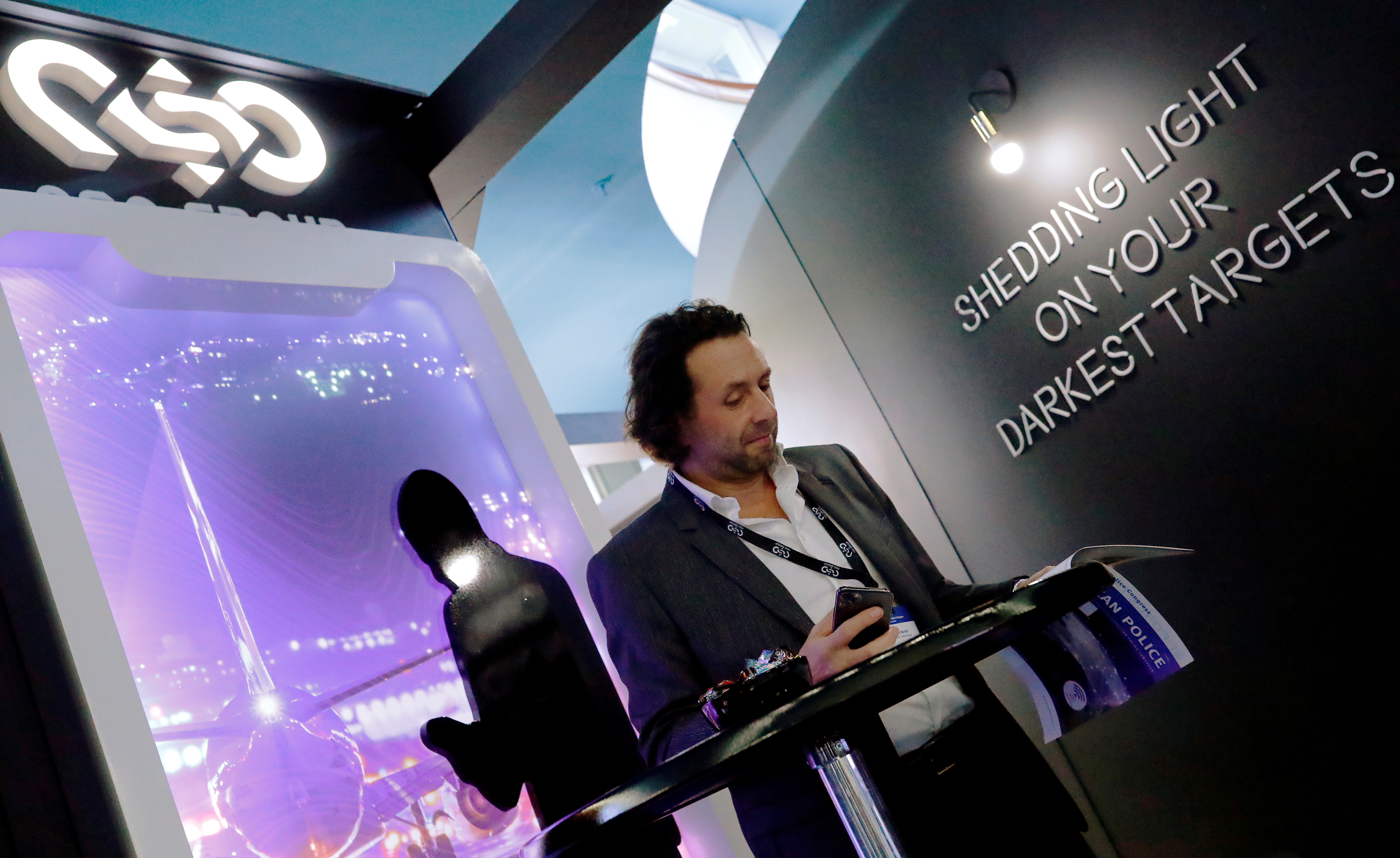 A man reads at a stand of the NSO Group Technologies, an Israeli technology firm known for its Pegasus spyware enabling the remote surveillance of smartphones, at the annual European Police Congress in Berlin