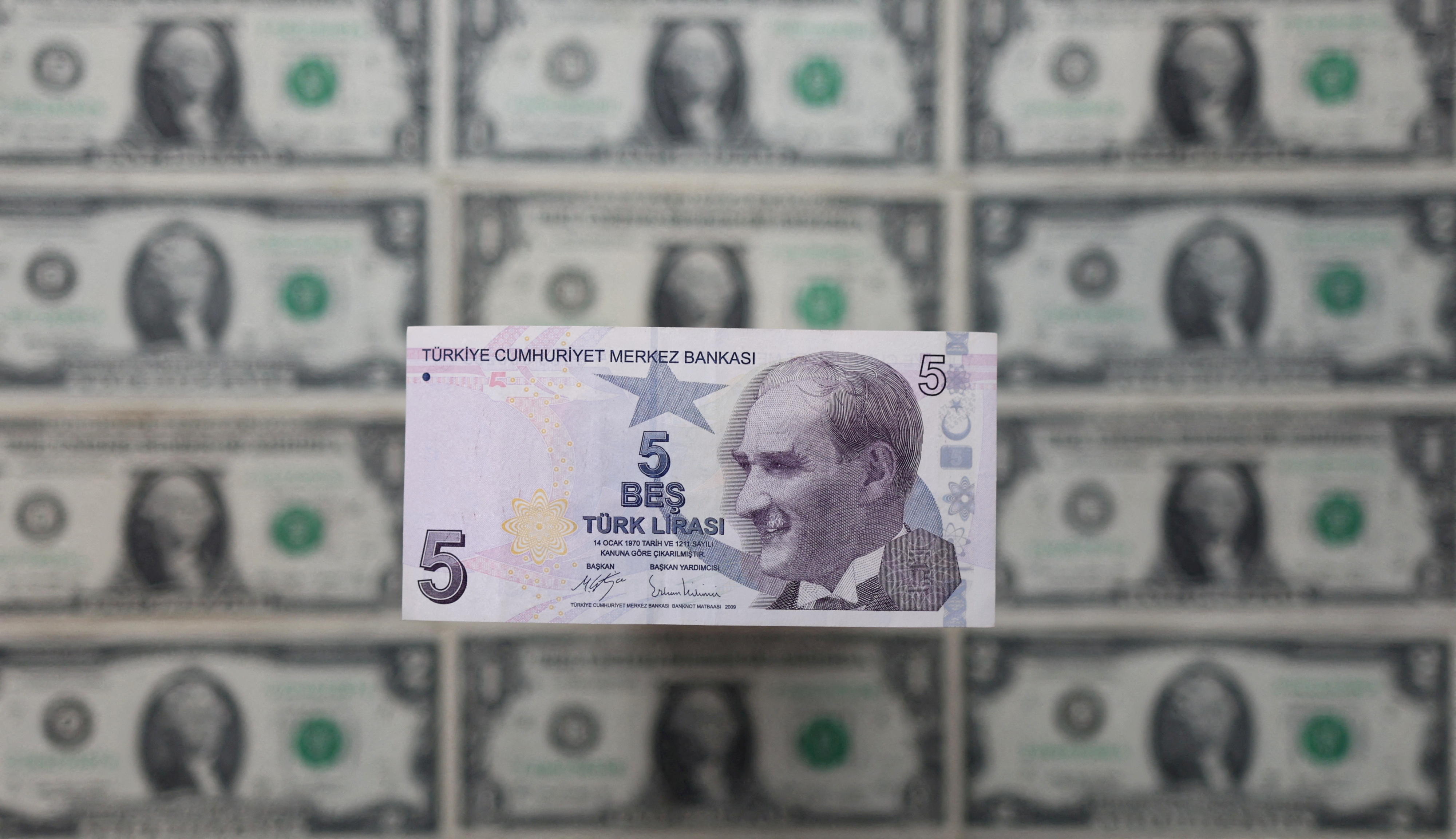 Illustration shows Turkish lira banknote placed on U.S. Dollar banknotes