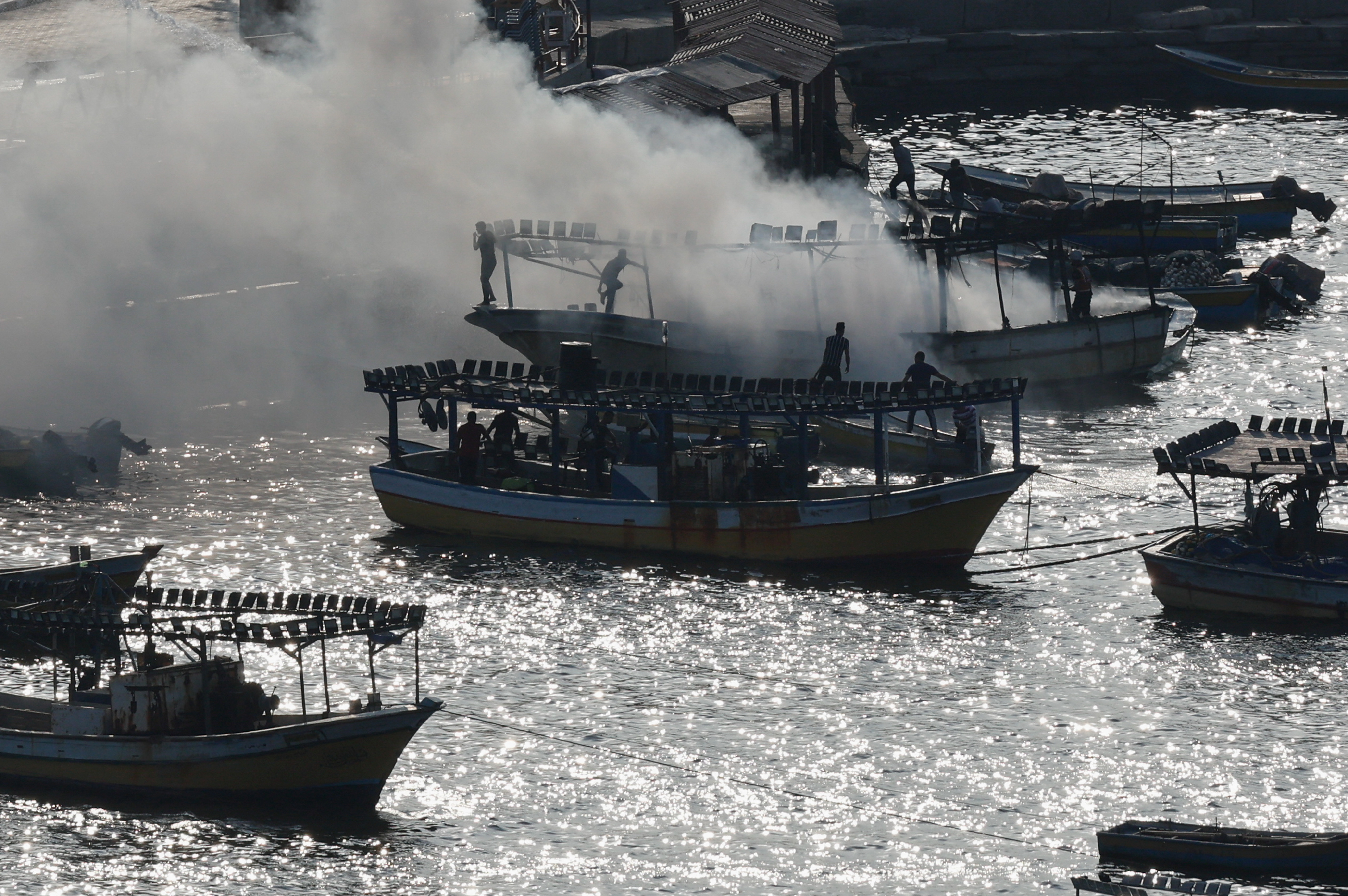 Smoke billows from a boat following Israeli strikes, seaport of Gaza City