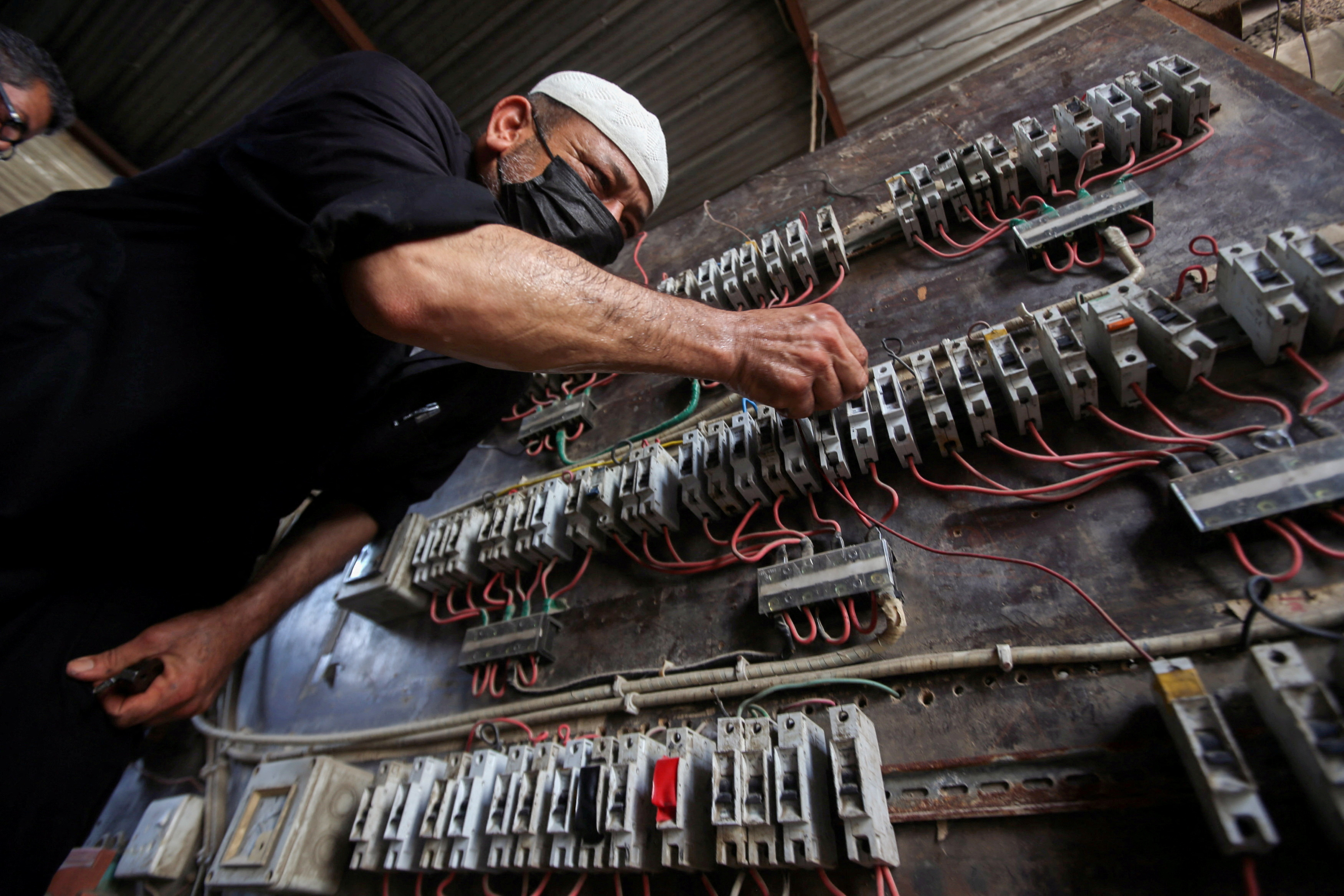 A man works on an electrical generator board during power outages in Basra