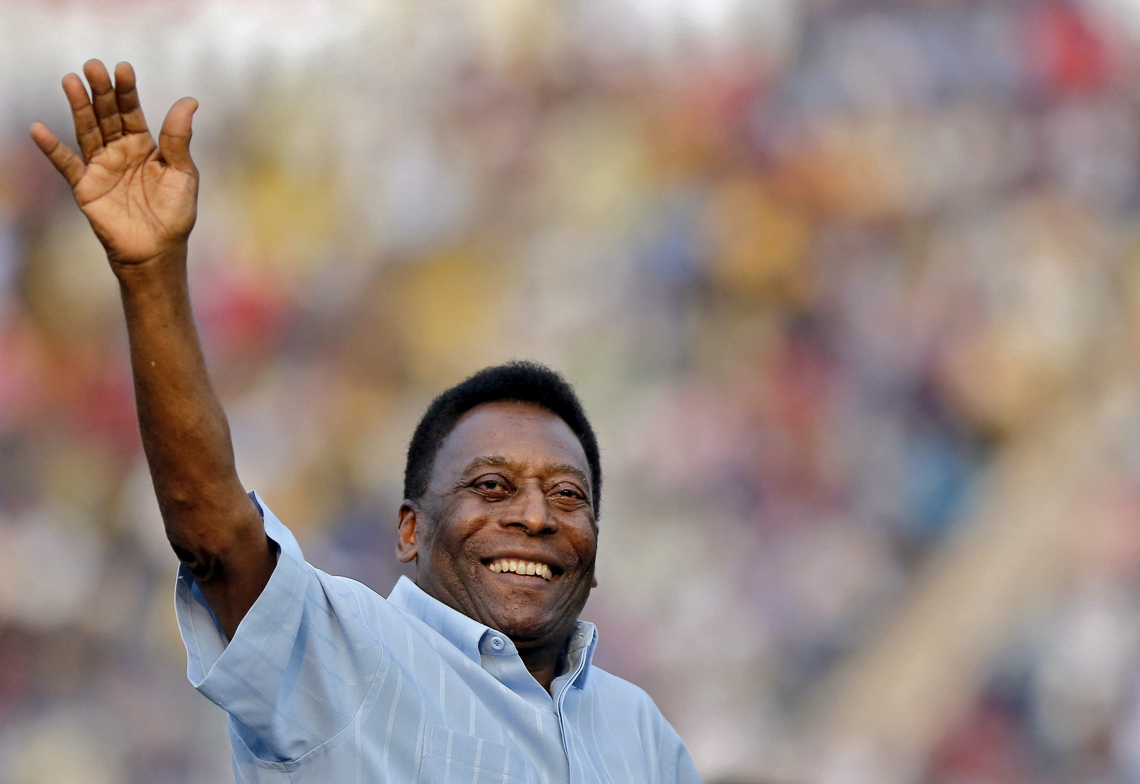 Brazilian football legend Pele waves to the crowd before the start of the men's under-17 final of the Subroto Cup tournament in New Delhi.