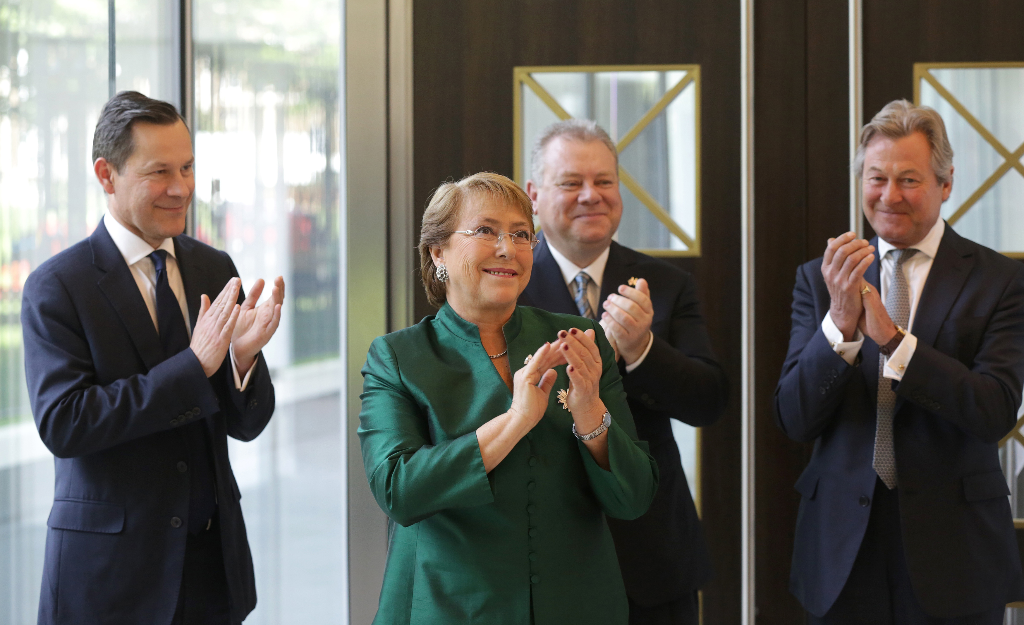 Chilean President Michelle Bachelet applauds at the official opening of new offices at the London Metal Exchange with Adrian Farnham (L) CEO of LME clear , CEO of LME Garry Jones and Richard Thornhill , Chairman of the LME clear board(R),London