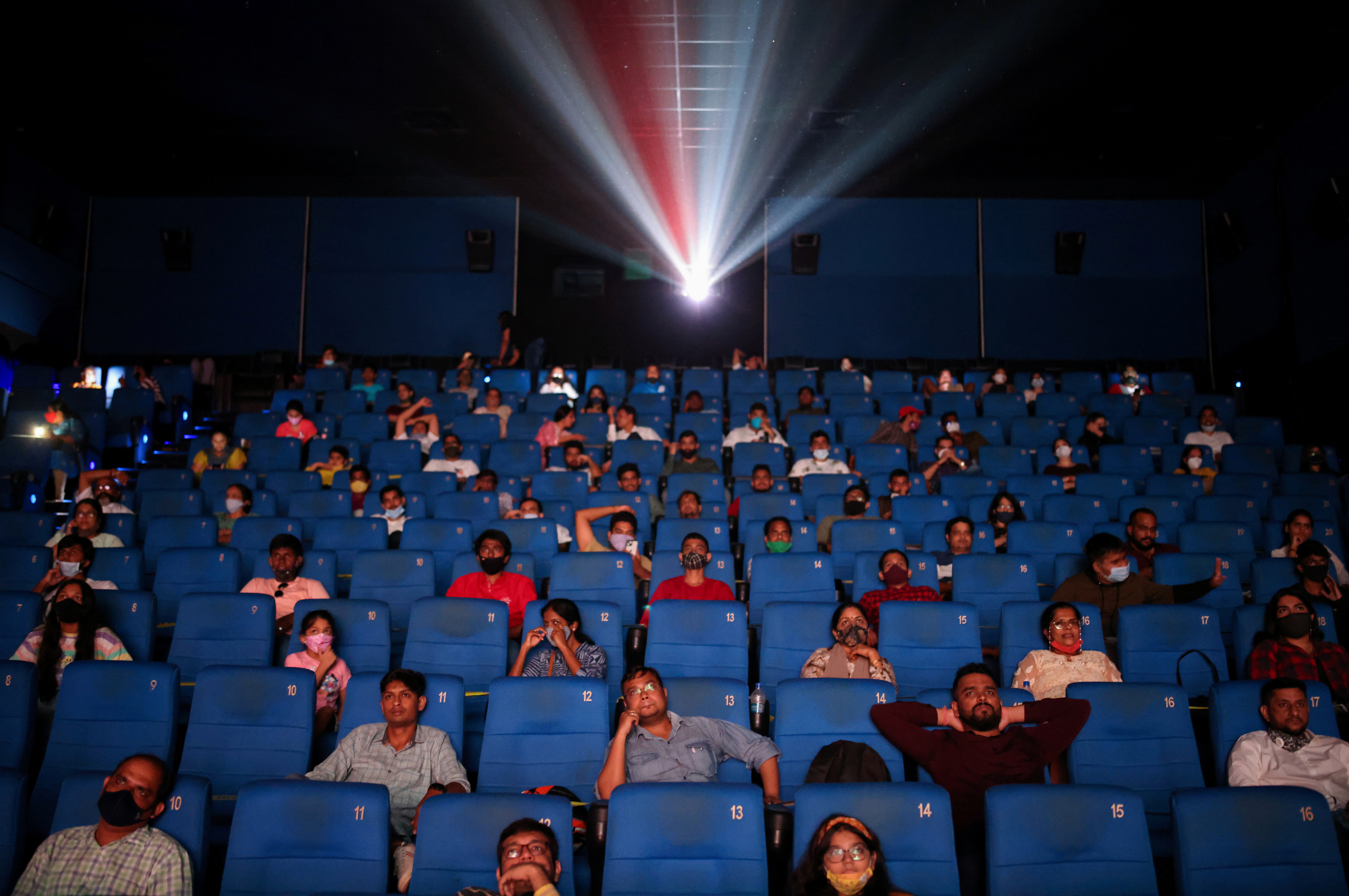 People watch a movie inside a cinema in Mumbai