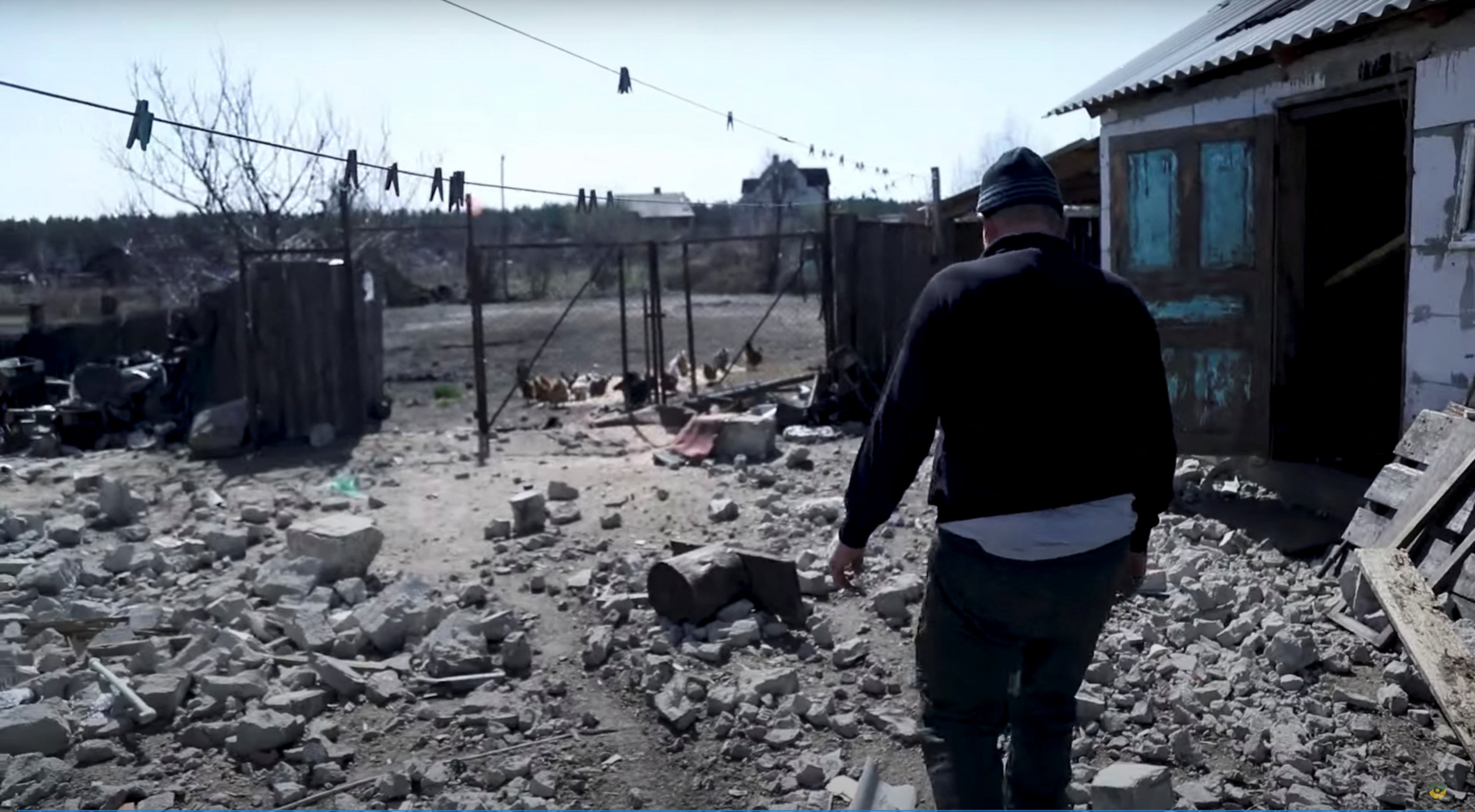 A resident walks among debris, amid Russia's invasion, in Moshchun village