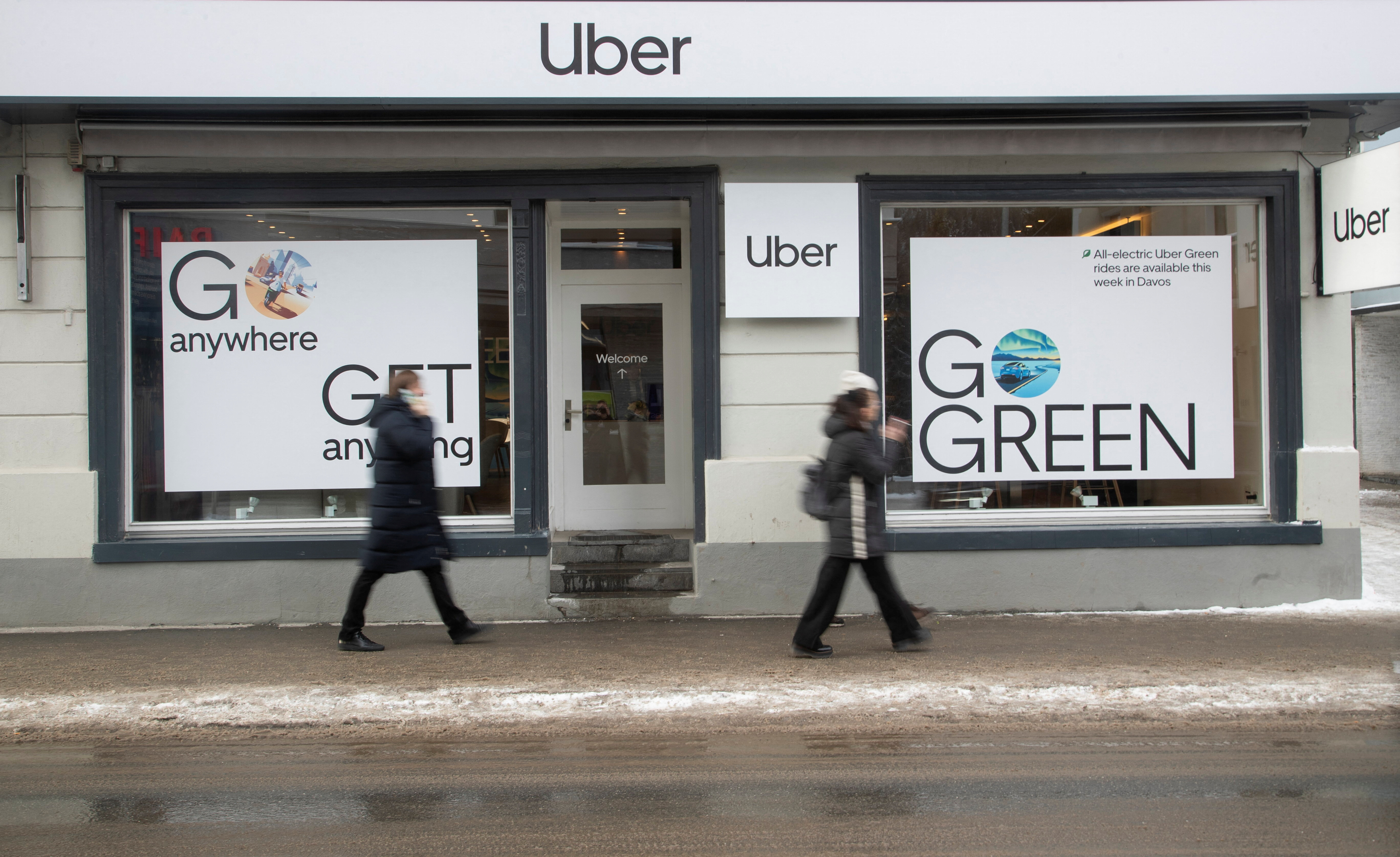 People walk past a temporary showroom of Uber during the World Economic Forum in Davos