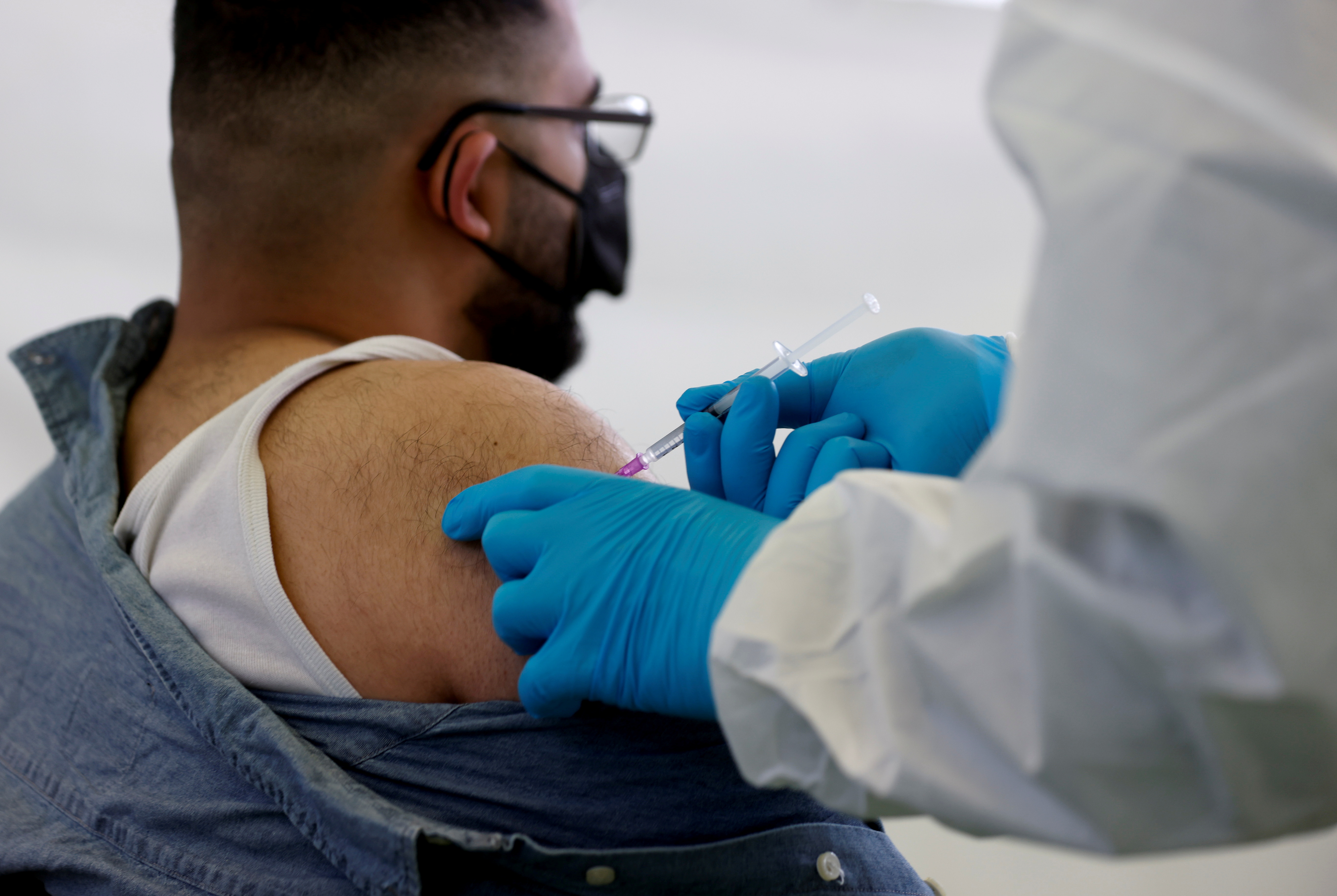 A person receives a vaccine against the coronavirus disease (COVID-19) at a sports hall in Berlin, Germany, May 14, 2021. REUTERS/Axel Schmidt/File Photo