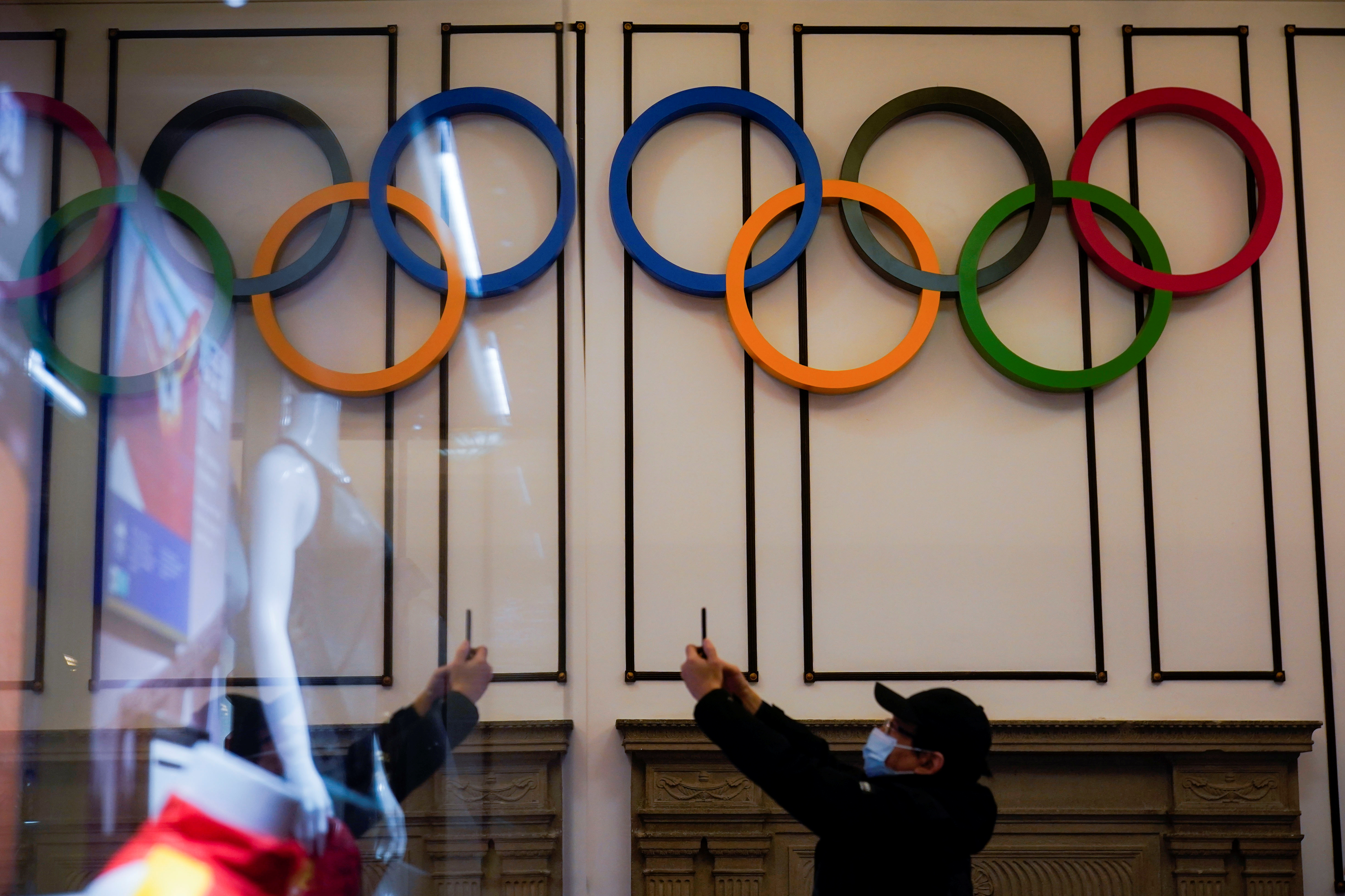 A visitor takes pictures near Olympic rings displayed at the Shanghai Sports Museum in Shanghai, China, December 8, 2021. REUTERS/Aly Song