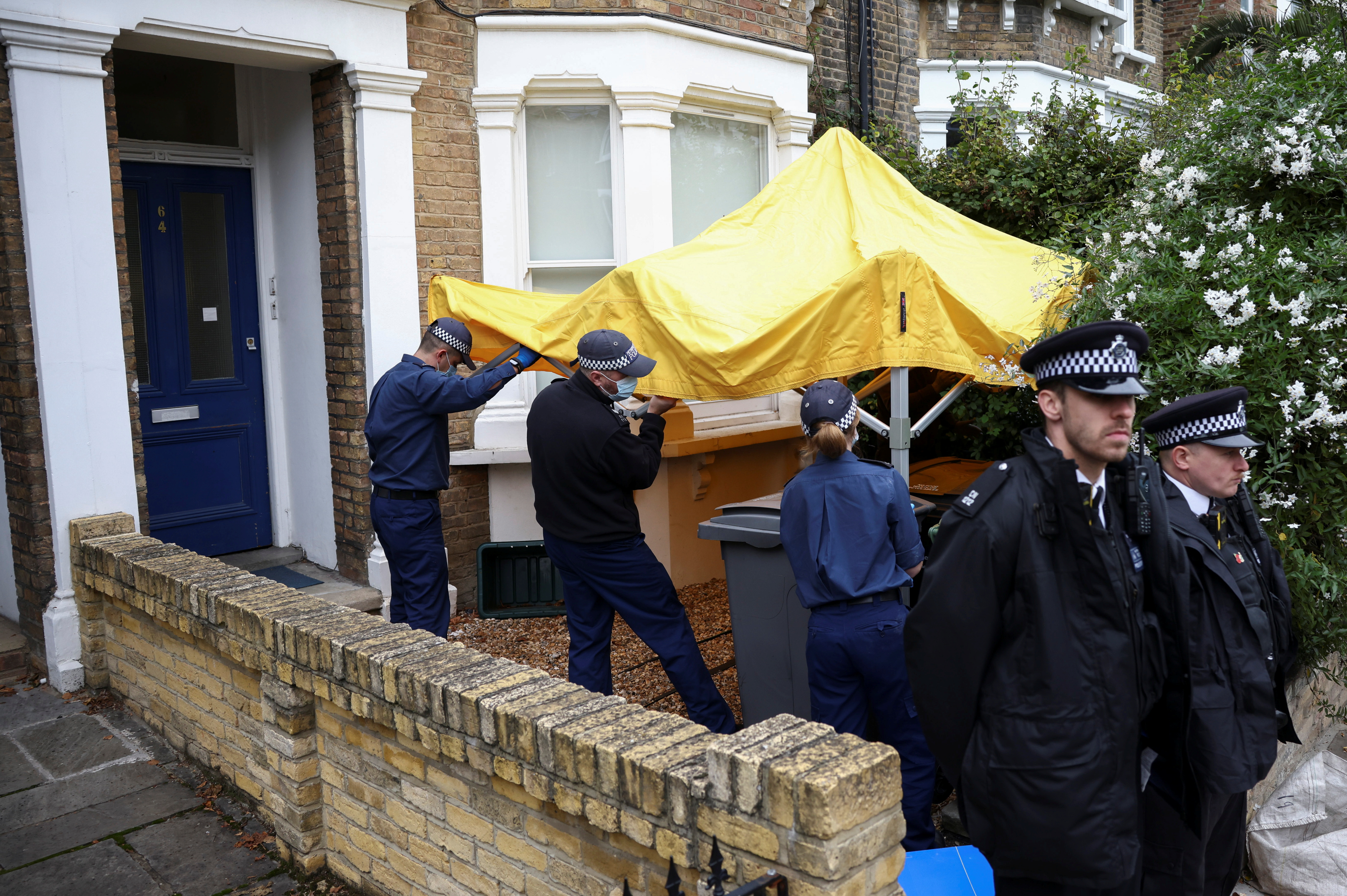 Police work at house believed to be address belonging to man arrested in connection with killing of British MP Amess, in London