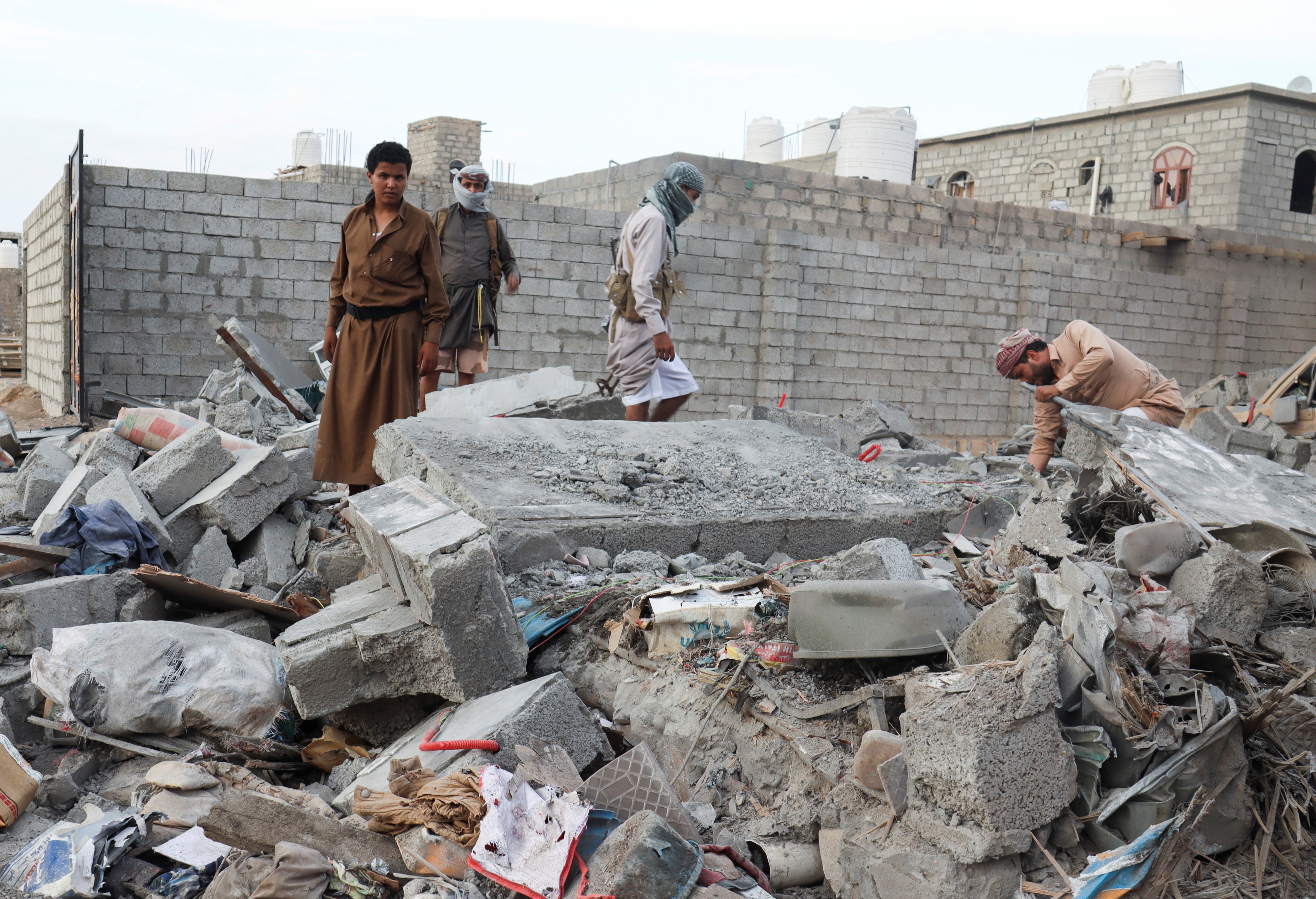 People browse through the rubble of a house destroyed by Houthi missile attack in Marib