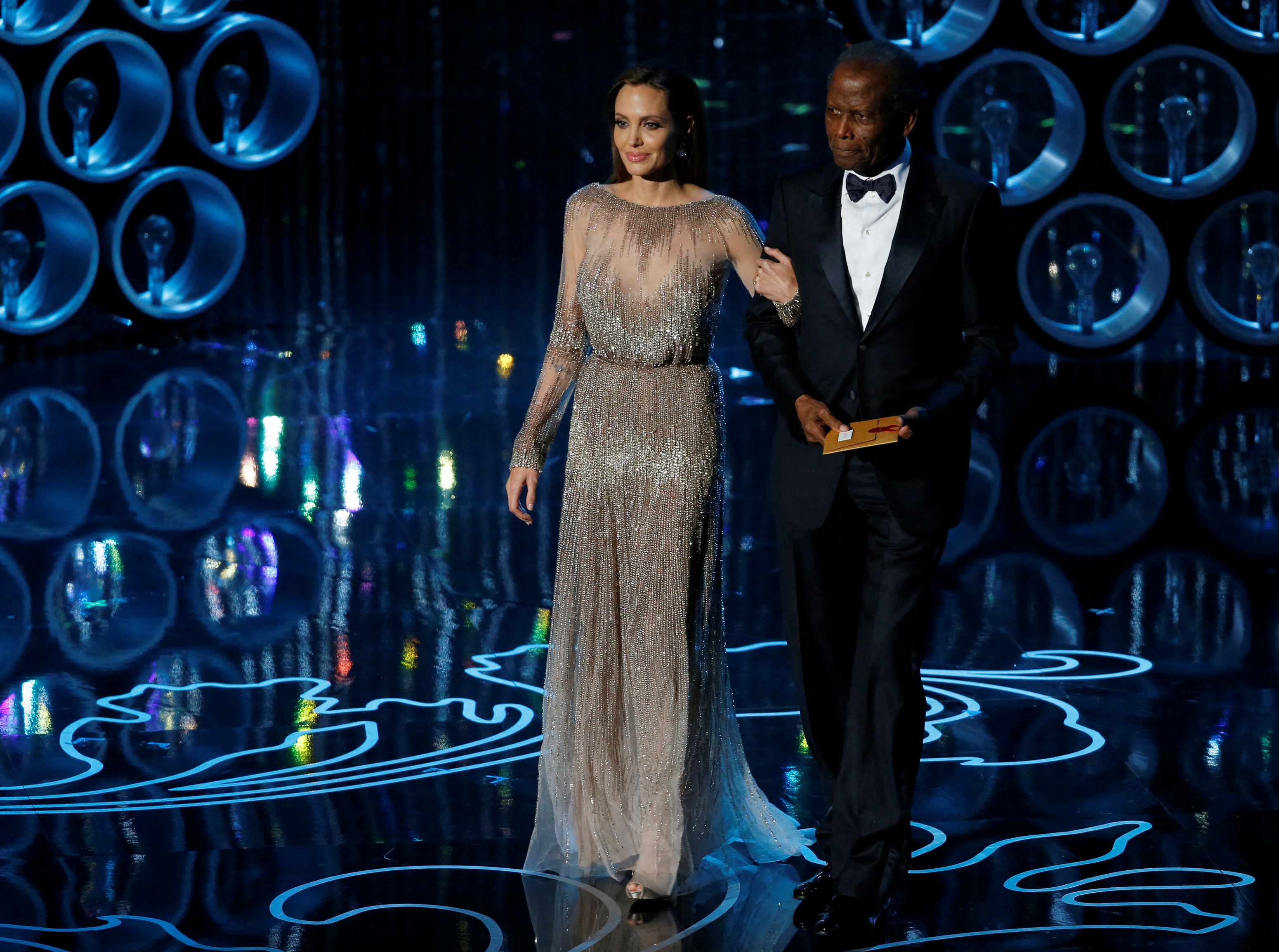Actors Angelina Jolie and Sidney Poitier take the stage to present the Oscar for achievement in directing at the 86th Academy Awards in Hollywood, California March 2, 2014. REUTERS/Lucy Nicholson