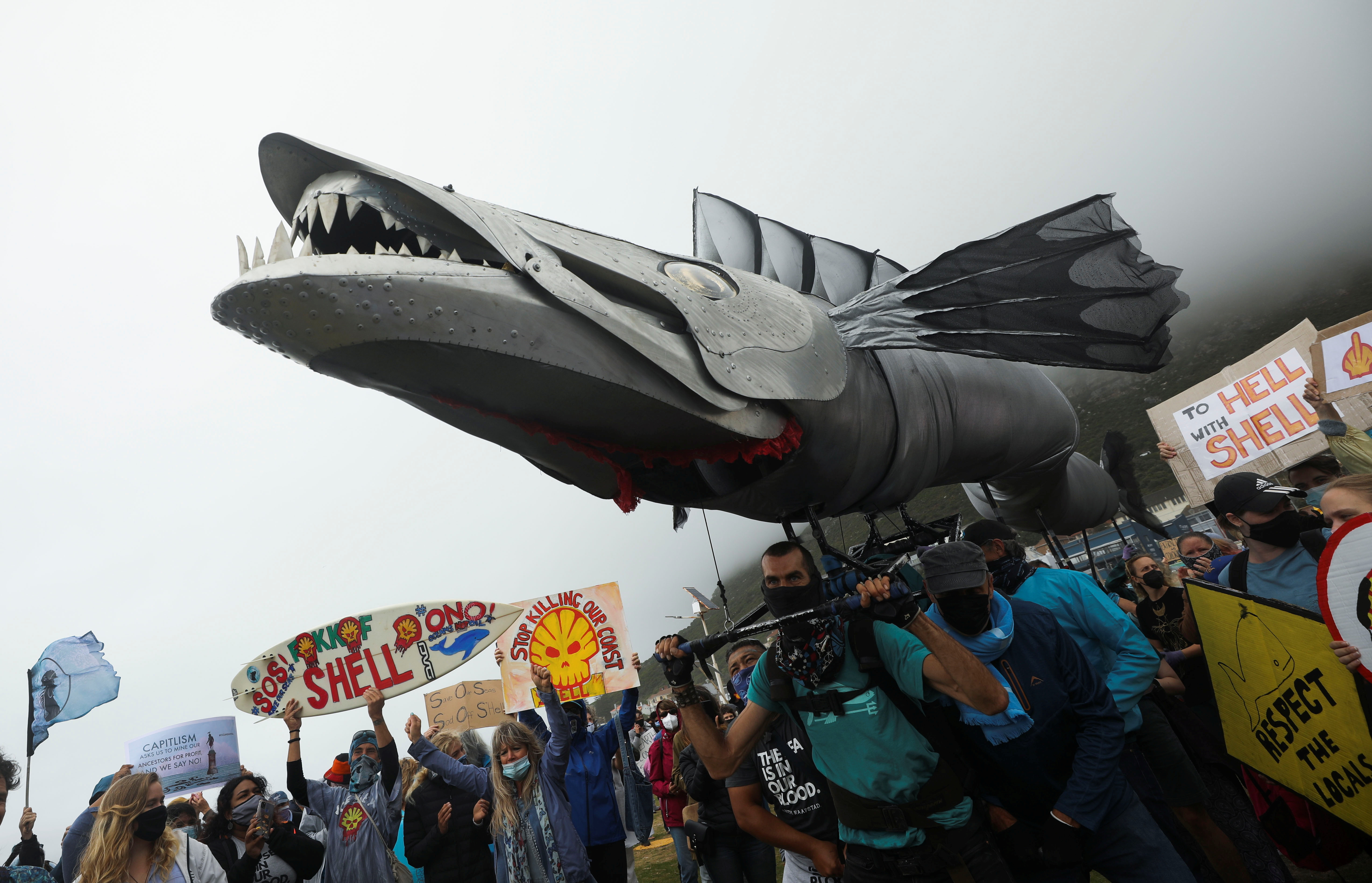 Protestors carry a huge fish puppet as they demonstrate against oil major Royal Dutch Shell's plans to start seismic surveys to explore for petroleum systems off the country's popular Wild Coast, at Muizenberg beach in Cape Town, South Africa, December 5. 2021. REUTERS/Mike Hutchings