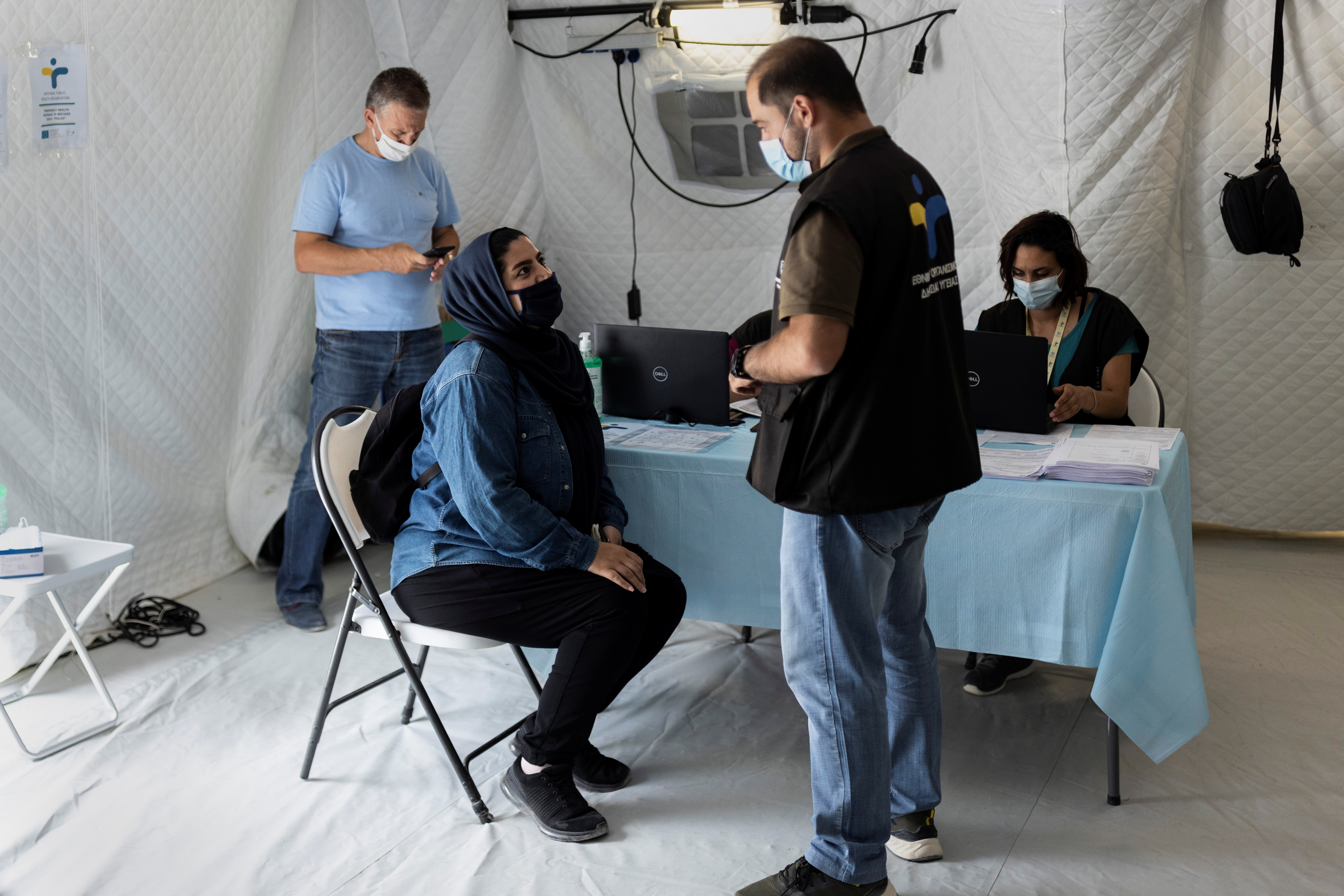 A migrant speaks with a Health ministry official before receiving a shot of the Johnson & Johnson vaccine against the coronavirus disease (COVID-19) in the Mavrovouni camp for refugees and migrants on the island of Lesbos, Greece, June 3, 2021. REUTERS/Alkis Konstantinidis