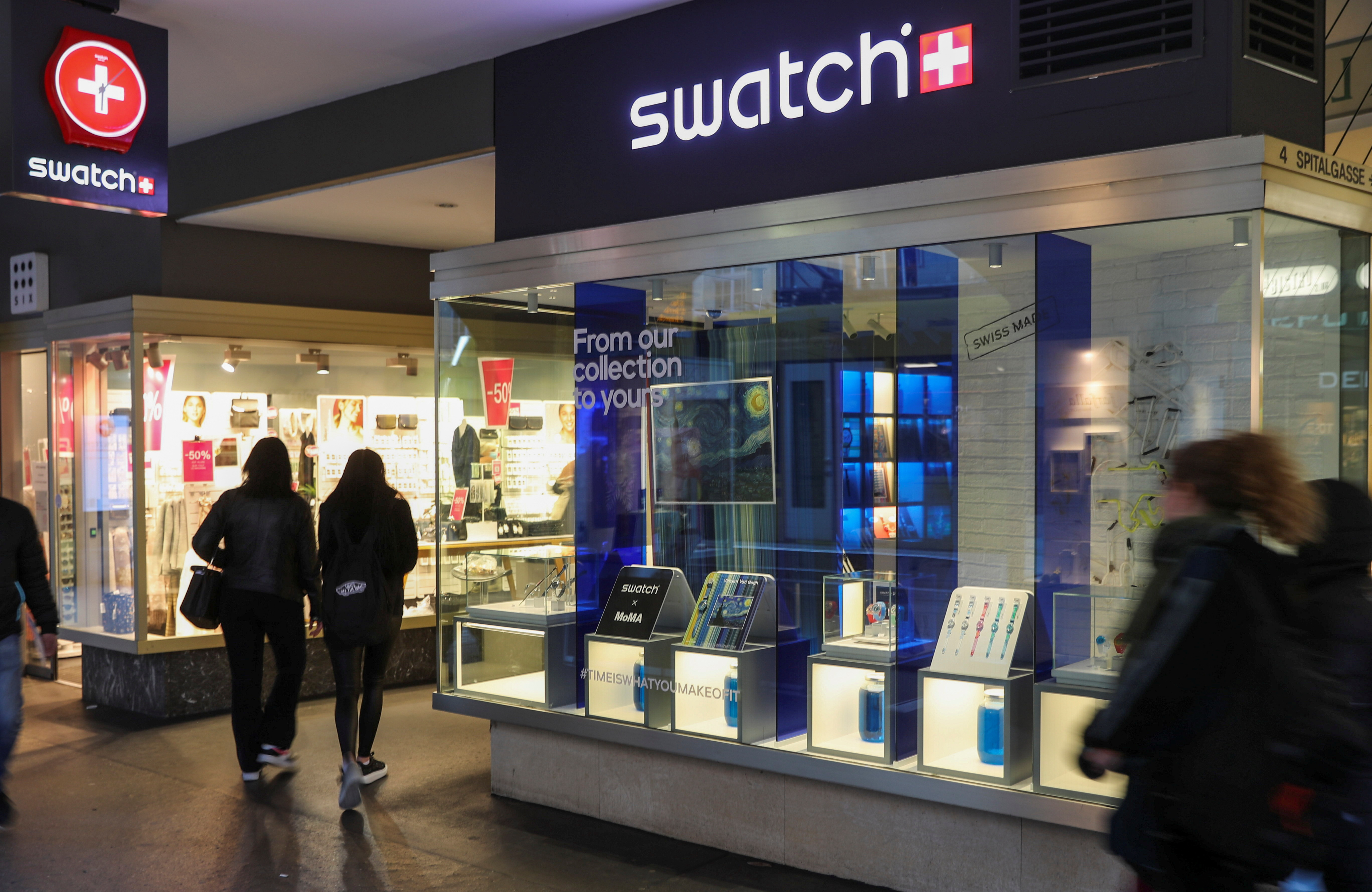 People walk past a shop of Swatch in Bern