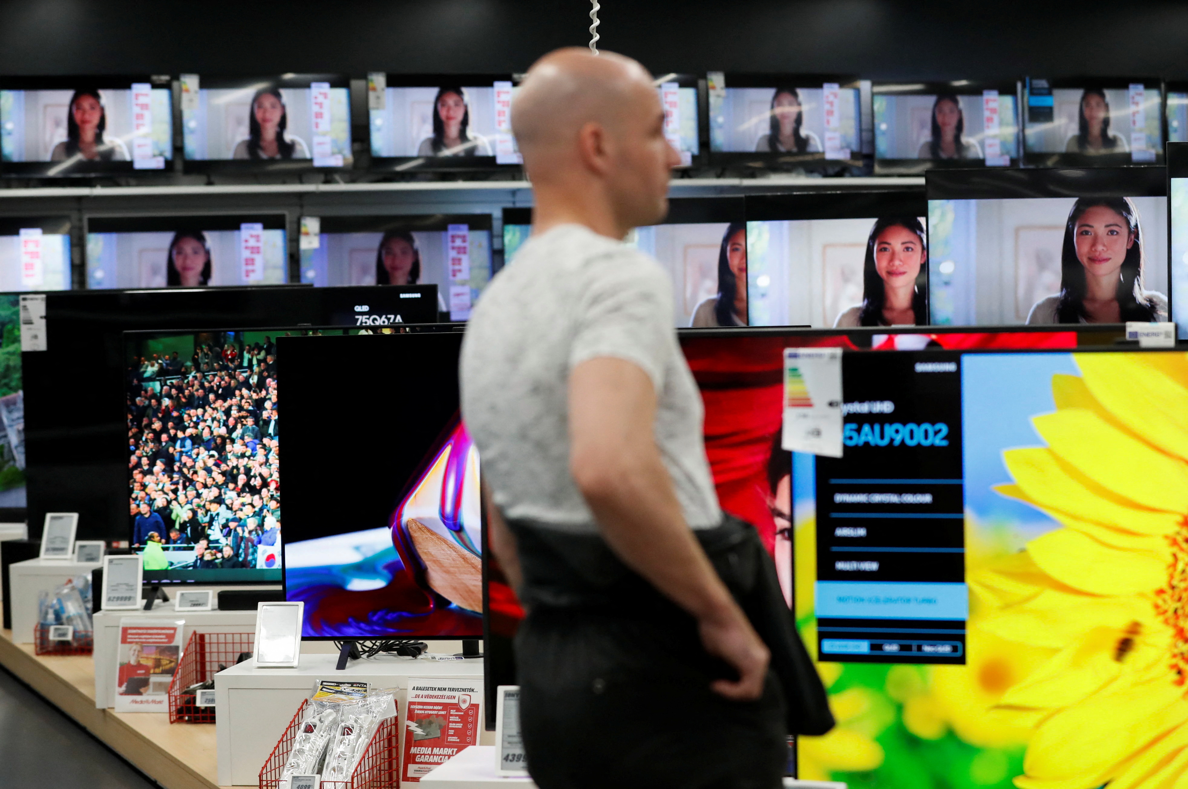 A man walks past television screens at consumer electronics retailer Media Markt in Budapest
