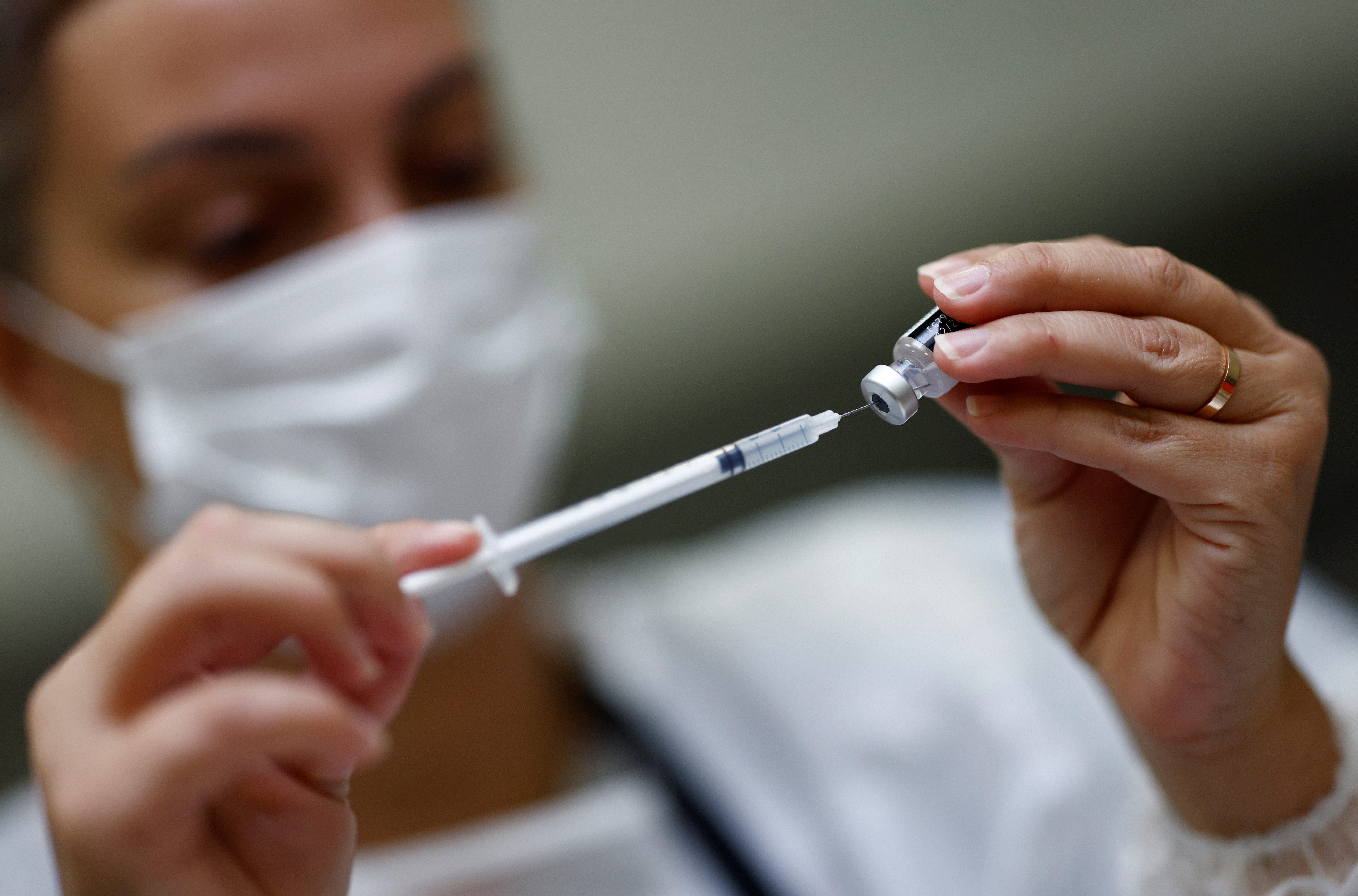 A medical worker prepares a dose of the "Comirnaty" Pfizer BioNTech COVID-19 vaccine in a vaccination center in Nantes, France, October 6, 2021. REUTERS/Stephane Mahe