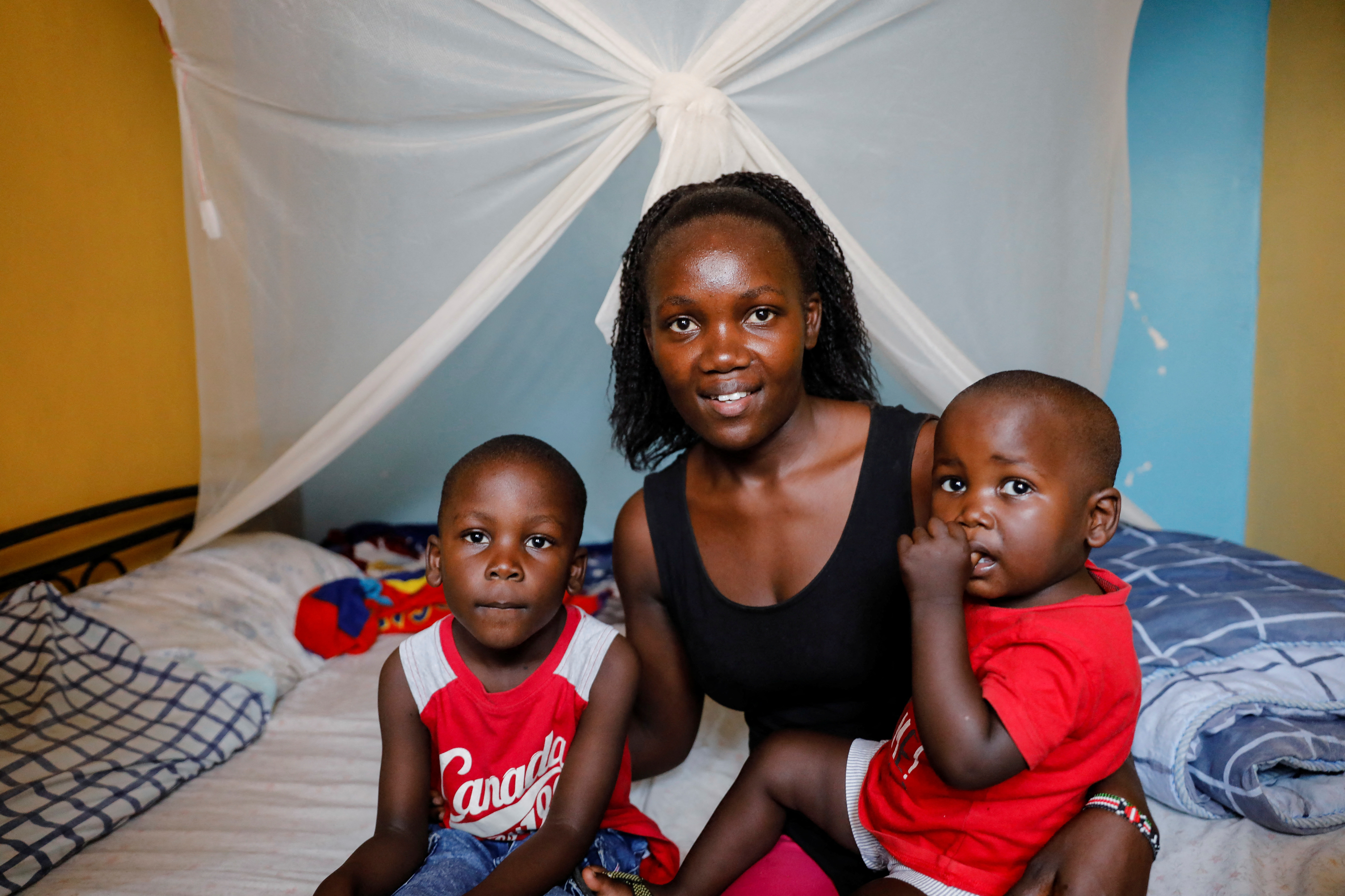 Rebecca Adhiamba Kwanya poses for a photo with her sons Betrun and Bradley at their home in Kisumu