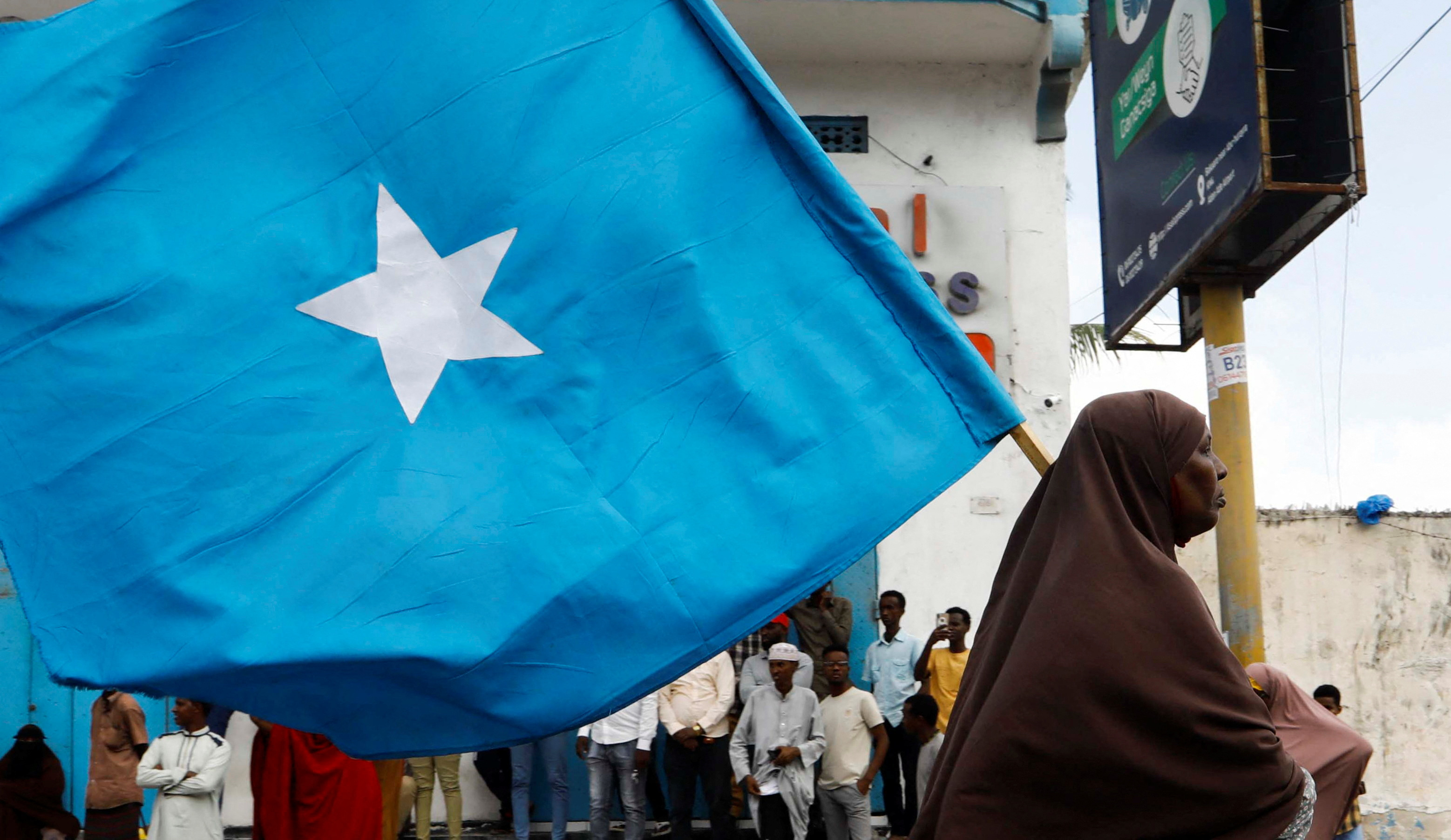 A Somali woman carries their flag during a march against the Ethiopia-Somaliland port deal along KM4 street in Mogadishu