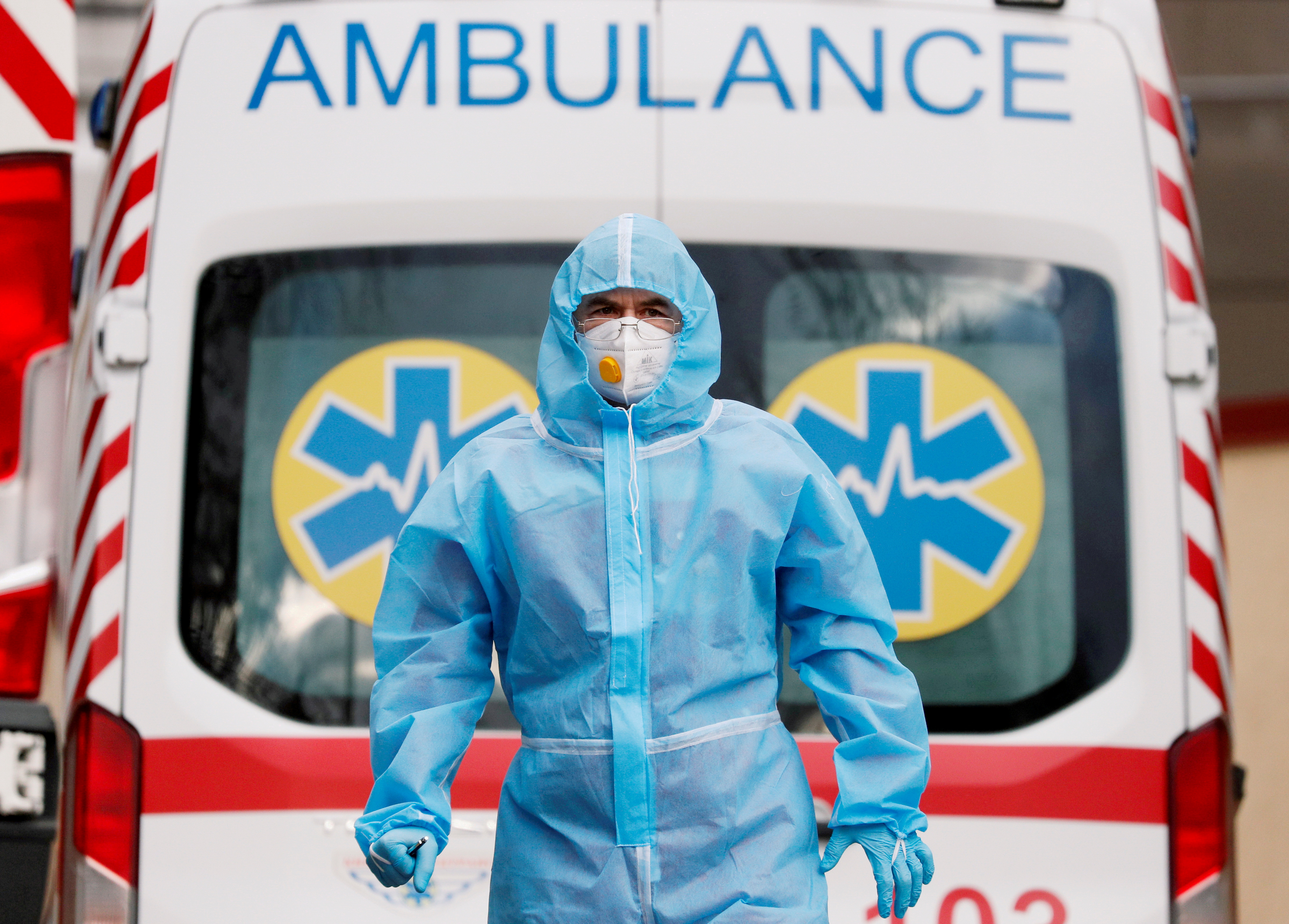 A medical worker wearing protective gear stands next to an ambulance outside a hospital for patients infected with COVID-19 in Kyiv, Ukraine, November 24, 2020.  REUTERS/Gleb Garanich/File Photo
