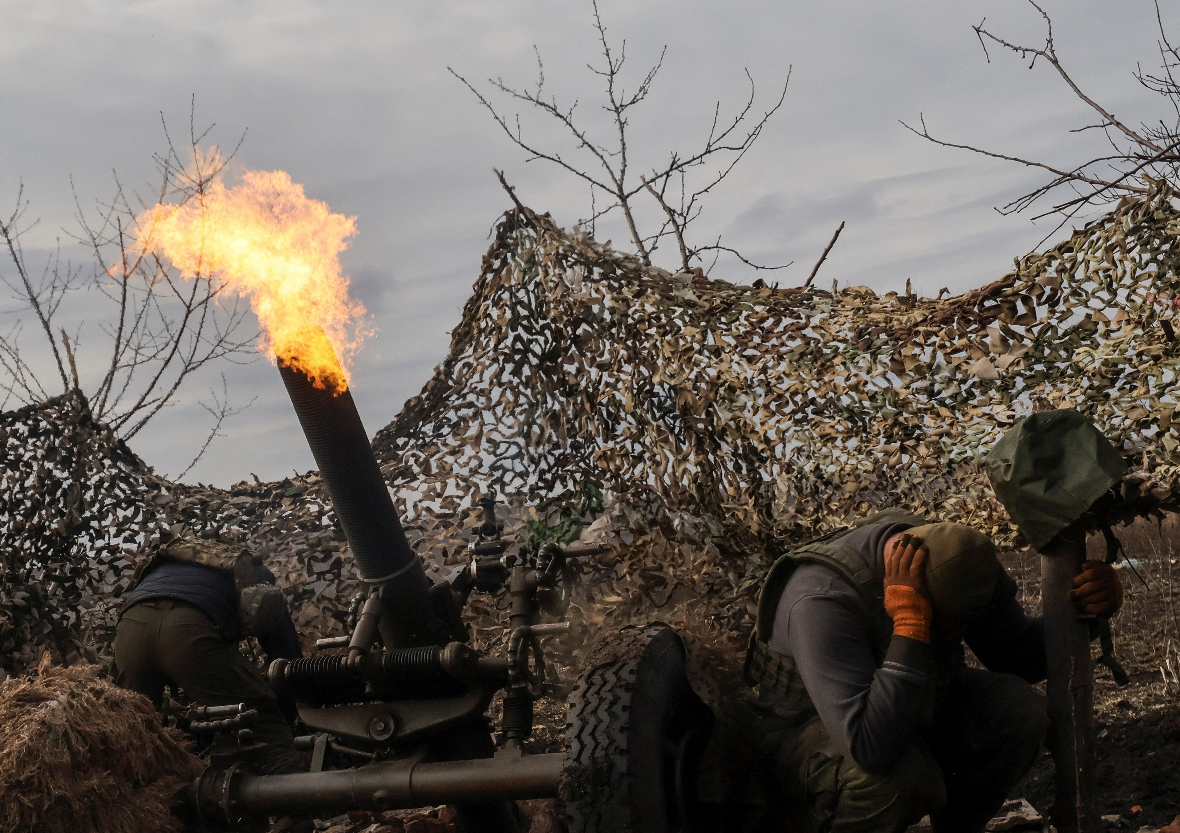 Ukrainian service members fire a mortar towards Russian troops outside the frontline town of Bakhmut