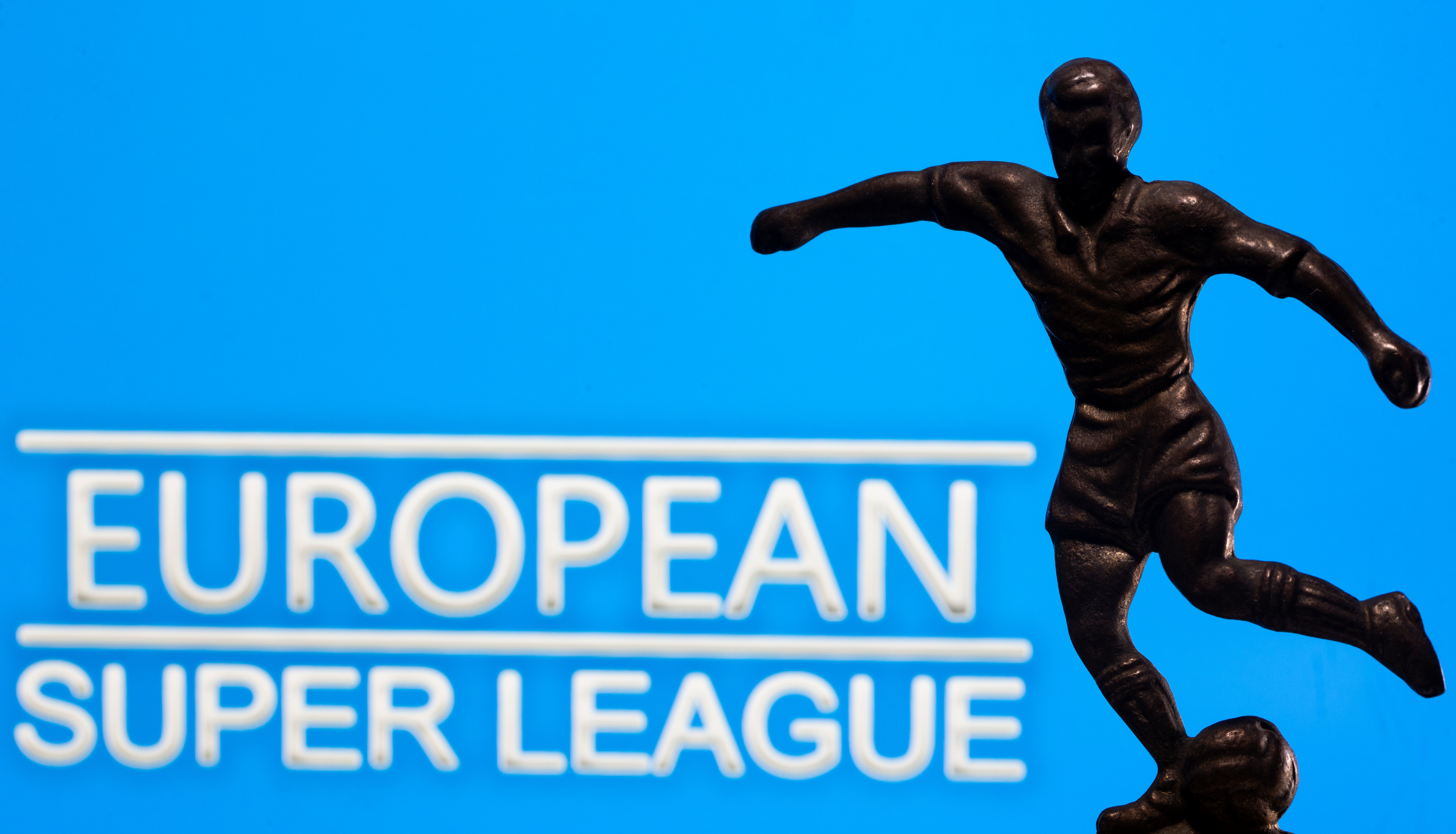 A metal figure of a football player with a ball is seen in front of the words 