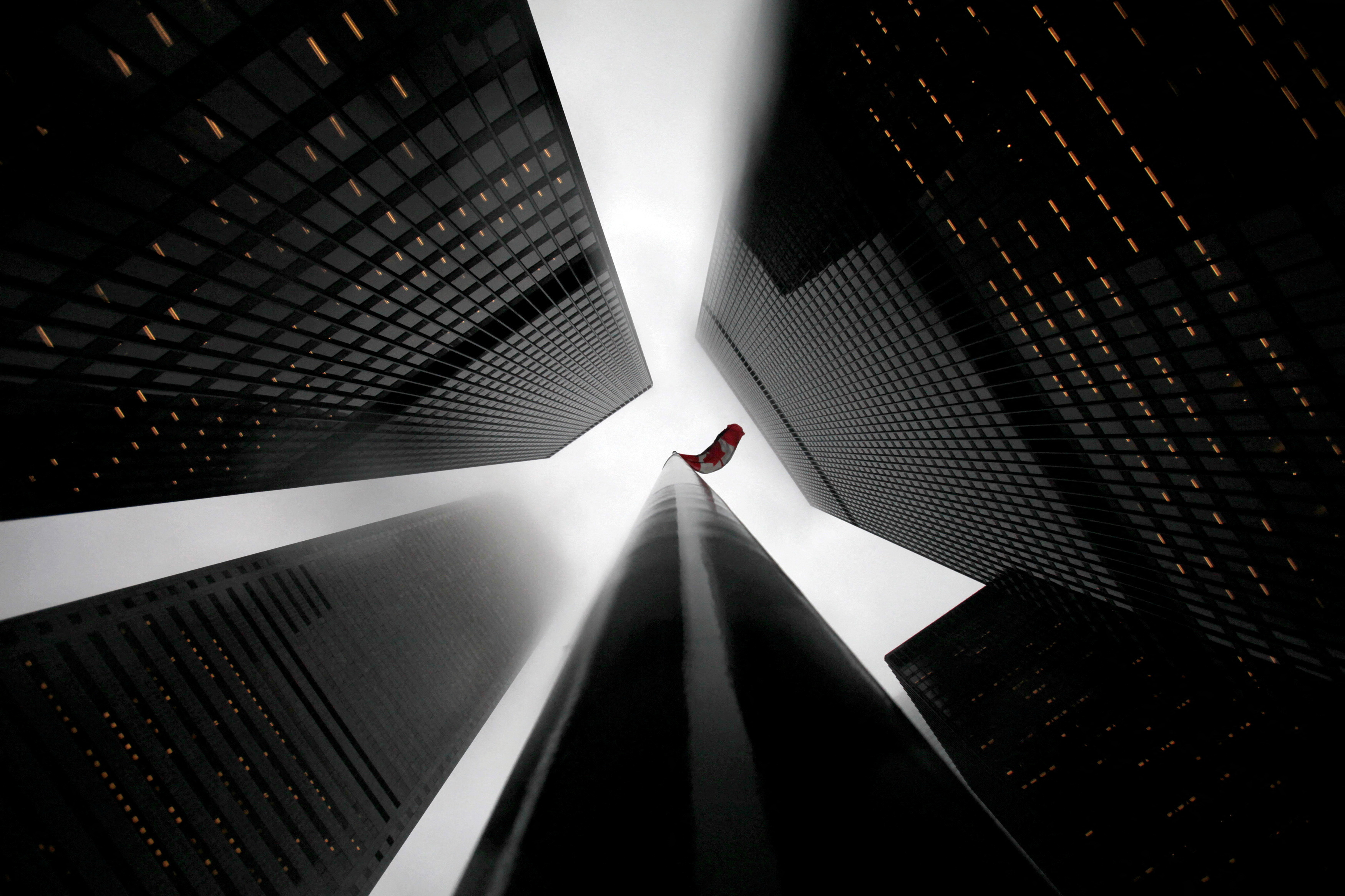 FILE PHOTO: The Canadian flag is seen on top of a flagpole in the midst of high-rise buildings in the financial district of Toronto, Canada